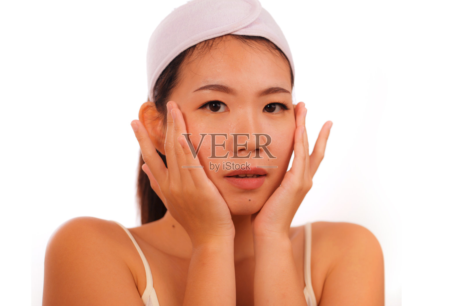 孤立肖像年轻美丽和快乐的亚洲韩国女性在化妆化妆和健康的生活方式中，在她的脸上应用皮肤护理、皱纹预防治疗或衰老美容产品照片摄影图片