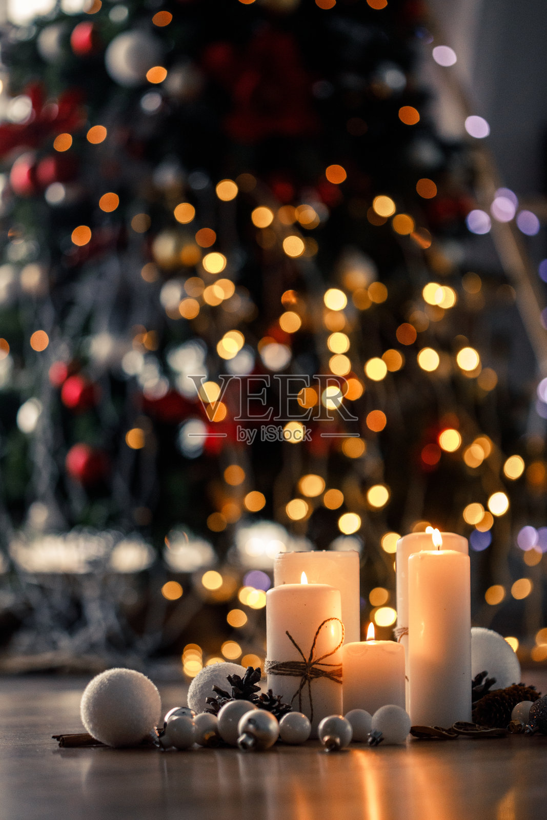 地板上放着白色的蜡烛和圣诞装饰品照片摄影图片