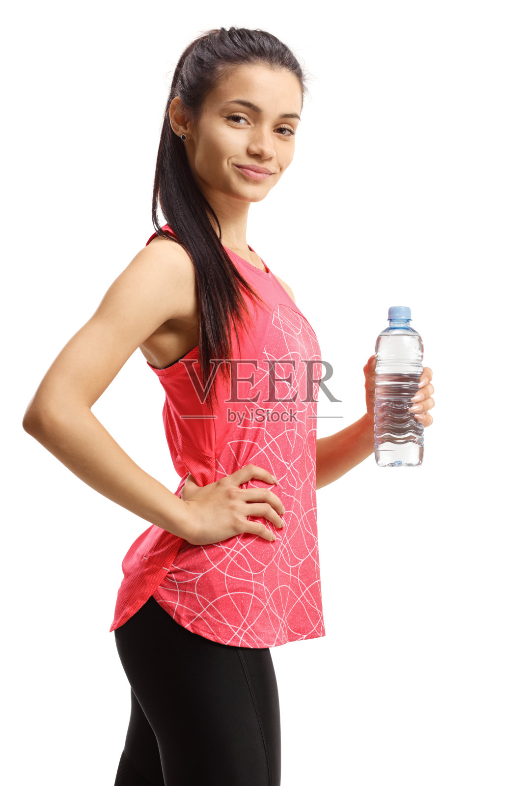 年轻女性穿着运动服，手里拿着一瓶水照片摄影图片