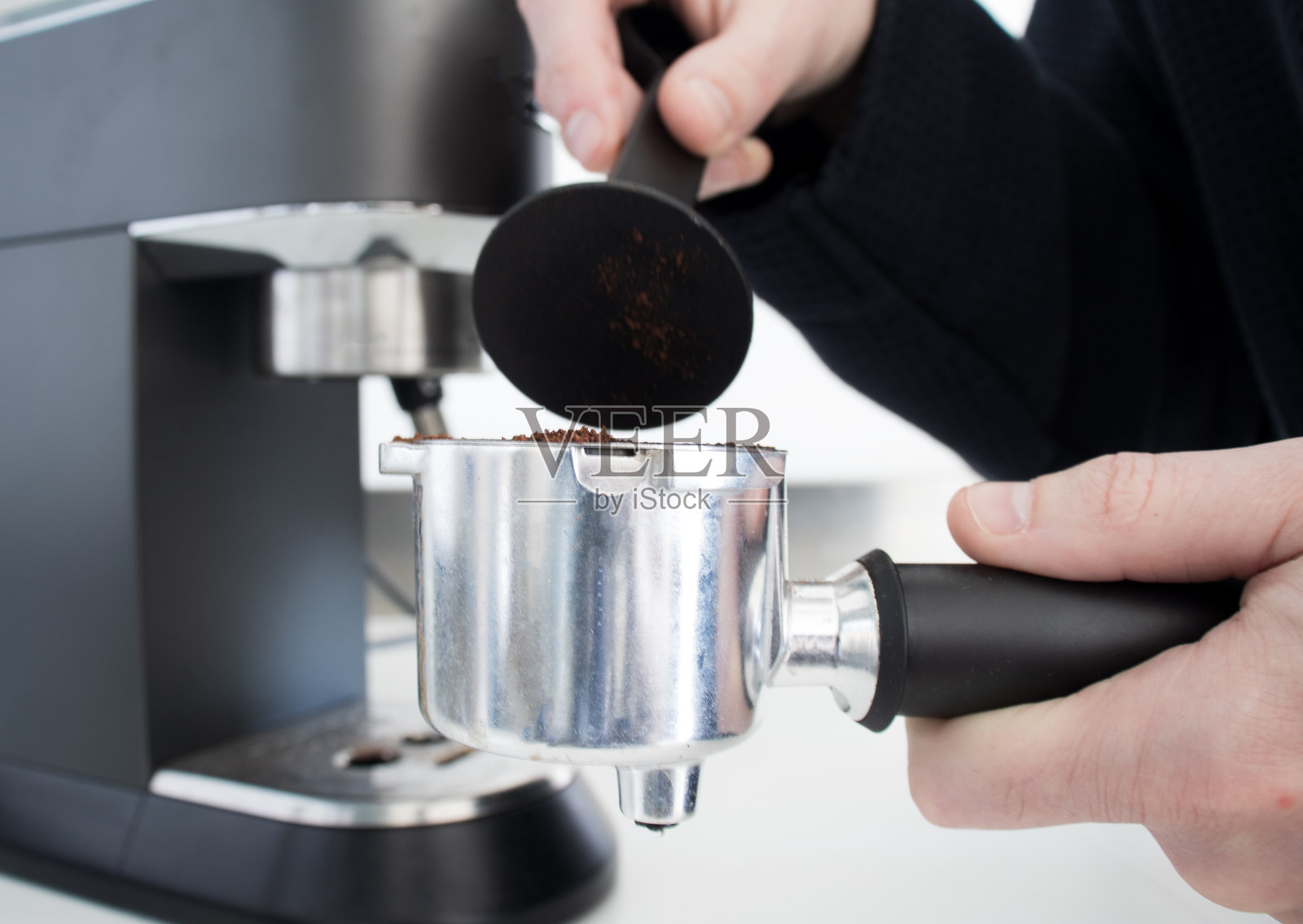 咖啡师是一种捣碎咖啡豆的咖啡，在早上做浓咖啡。照片摄影图片