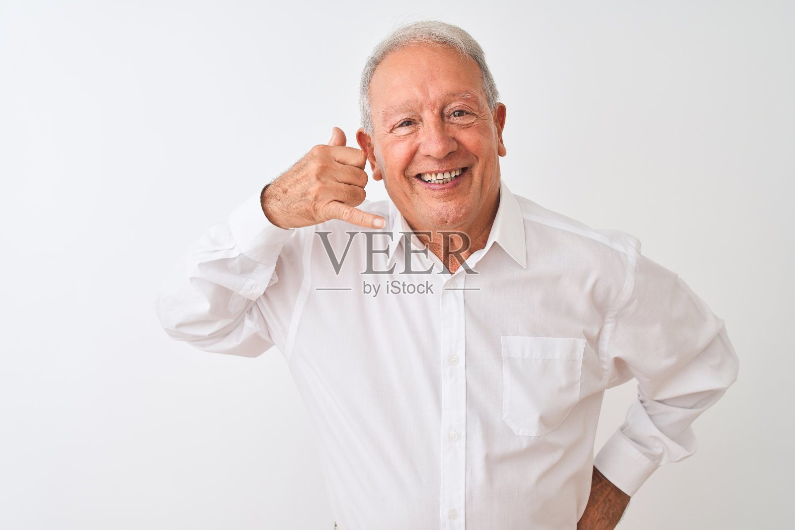 年长的灰白头发男子穿着优雅的衬衫站在孤立的白色背景做电话手势的手和手指像在打电话。沟通的概念。照片摄影图片