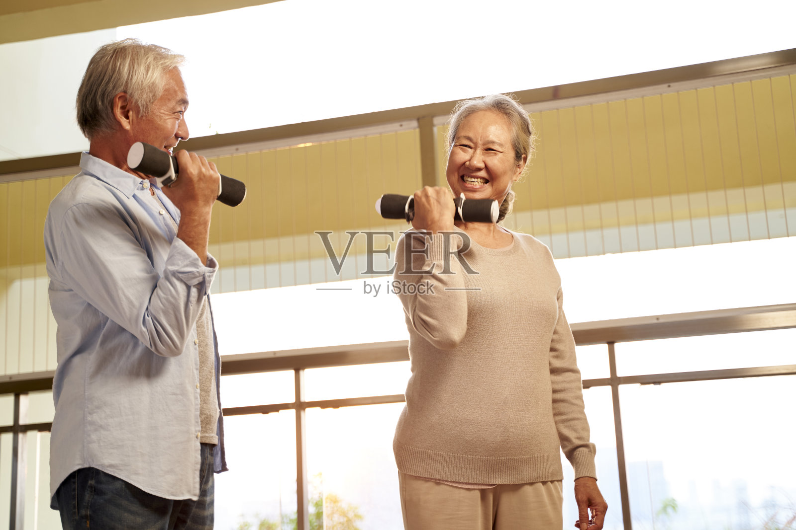 快乐的亚洲夫妇用哑铃锻炼照片摄影图片