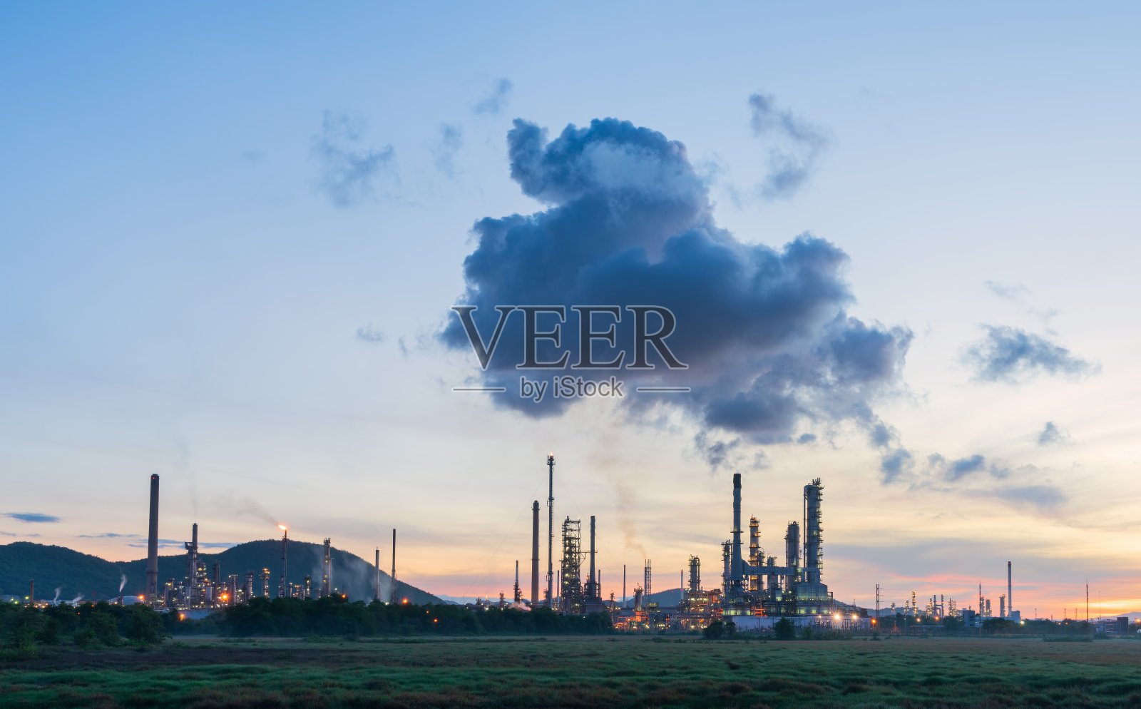 夕阳下美丽天空下的炼油厂。能源发电站。照片摄影图片