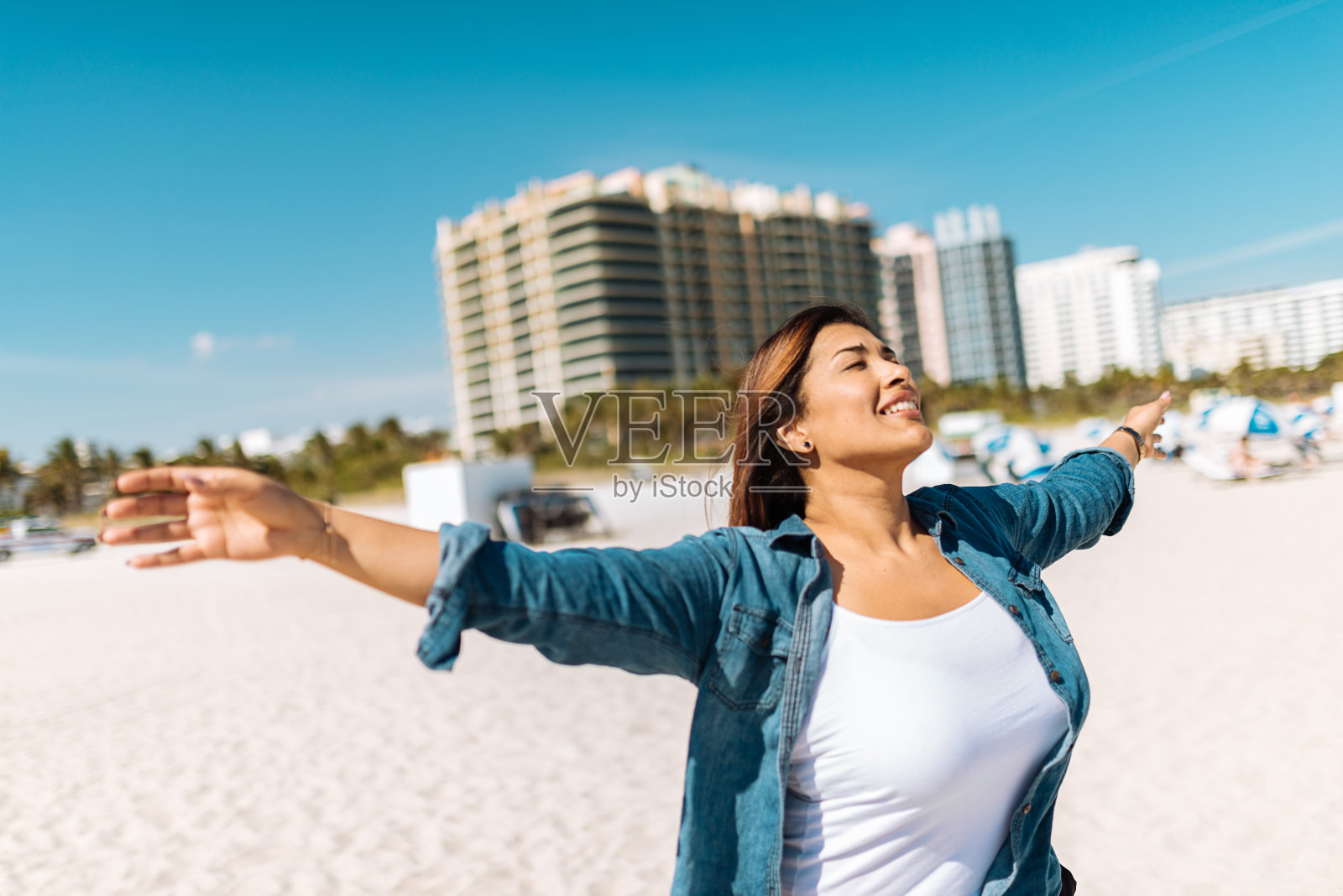 放松的拉丁成熟女子享受日光浴在海滩上照片摄影图片