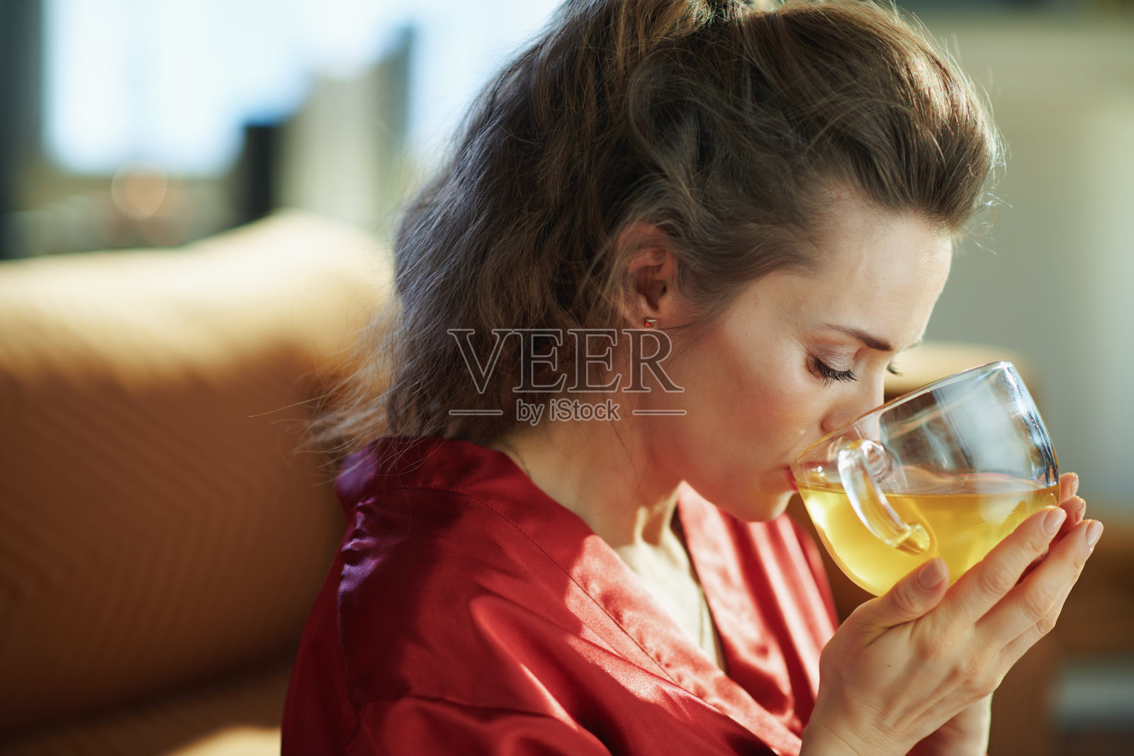 女人在阳光明媚的日子里在现代的家中喝着一杯绿茶照片摄影图片