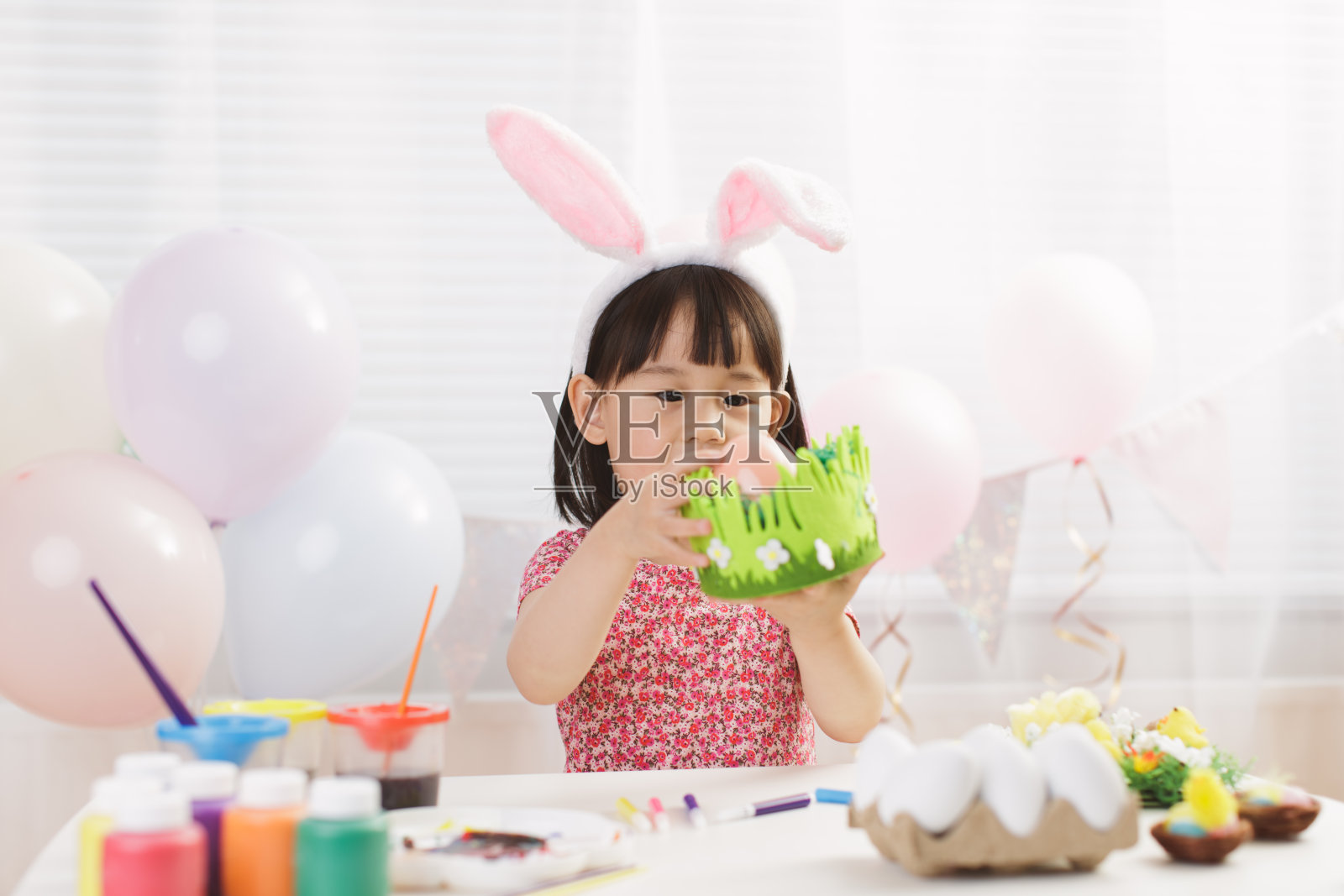 小女孩在家里的白色窗户背景下玩复活节彩蛋照片摄影图片