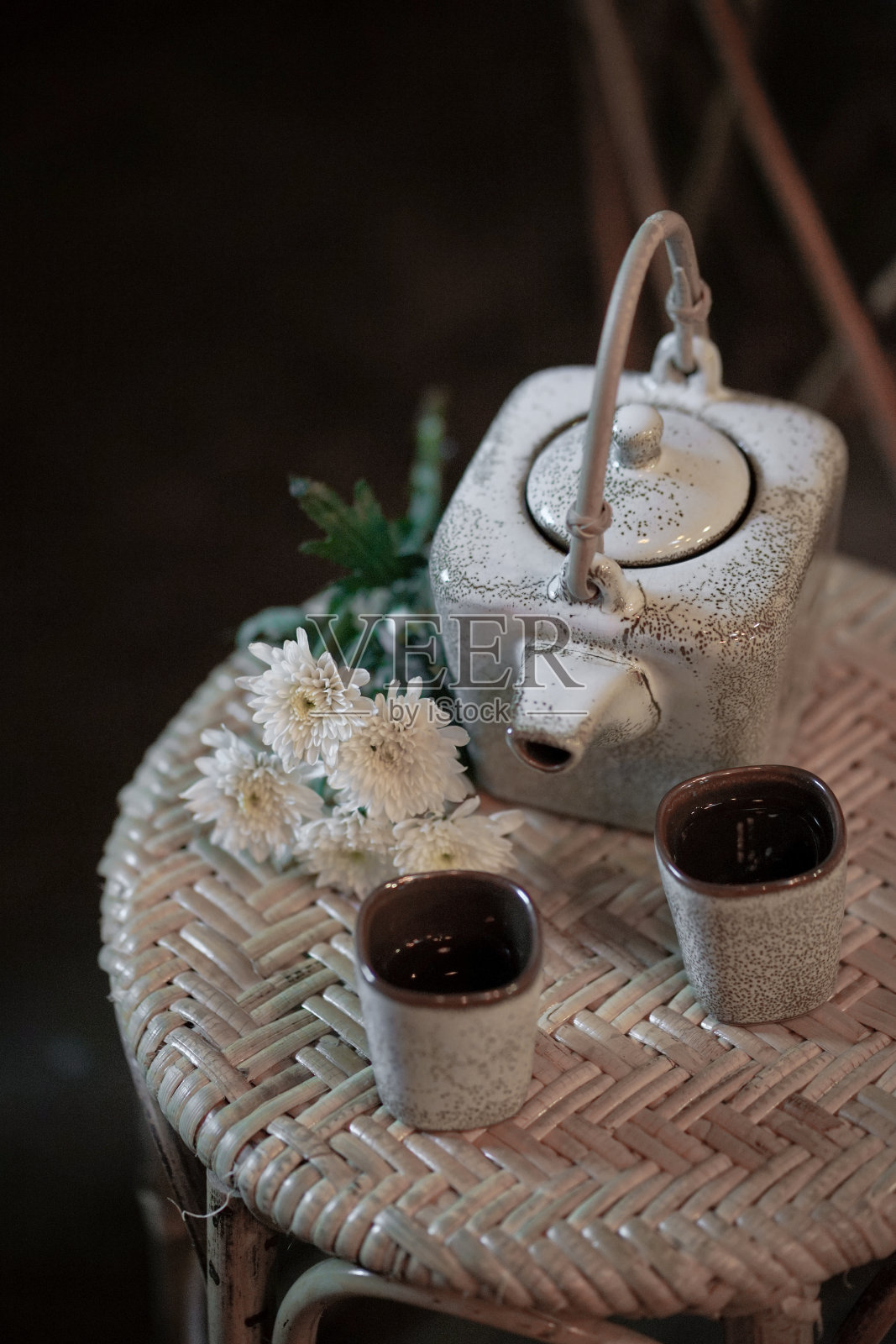 菊花茶壶和两杯菊花茶在旁边。复制左边的空间。照片摄影图片