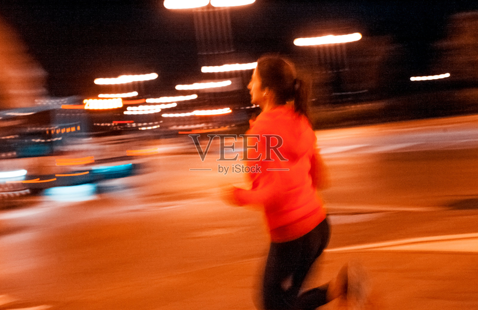 一个年轻女人晚上在城里跑来跑去照片摄影图片