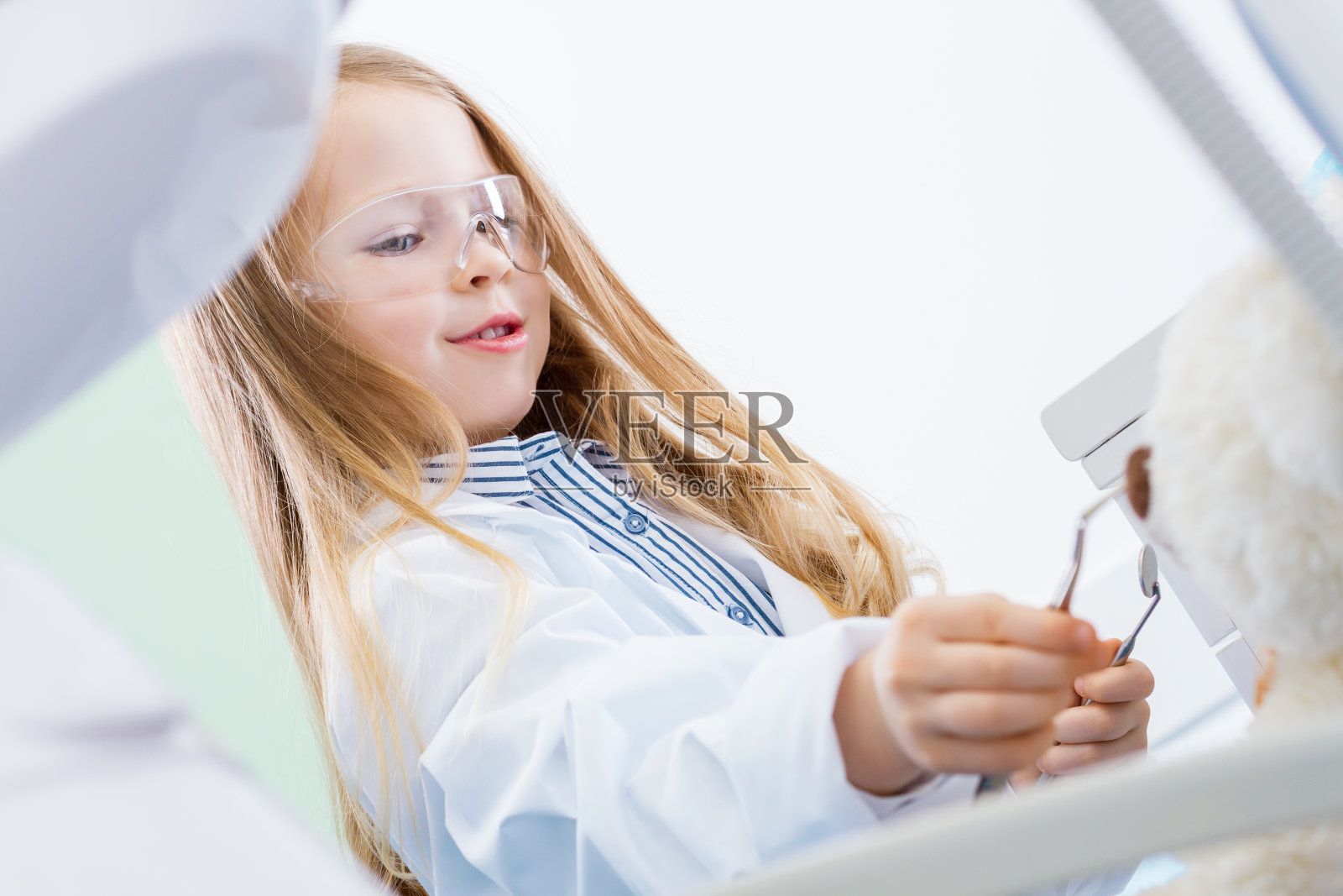 小女孩在牙医诊所里玩牙医照片摄影图片