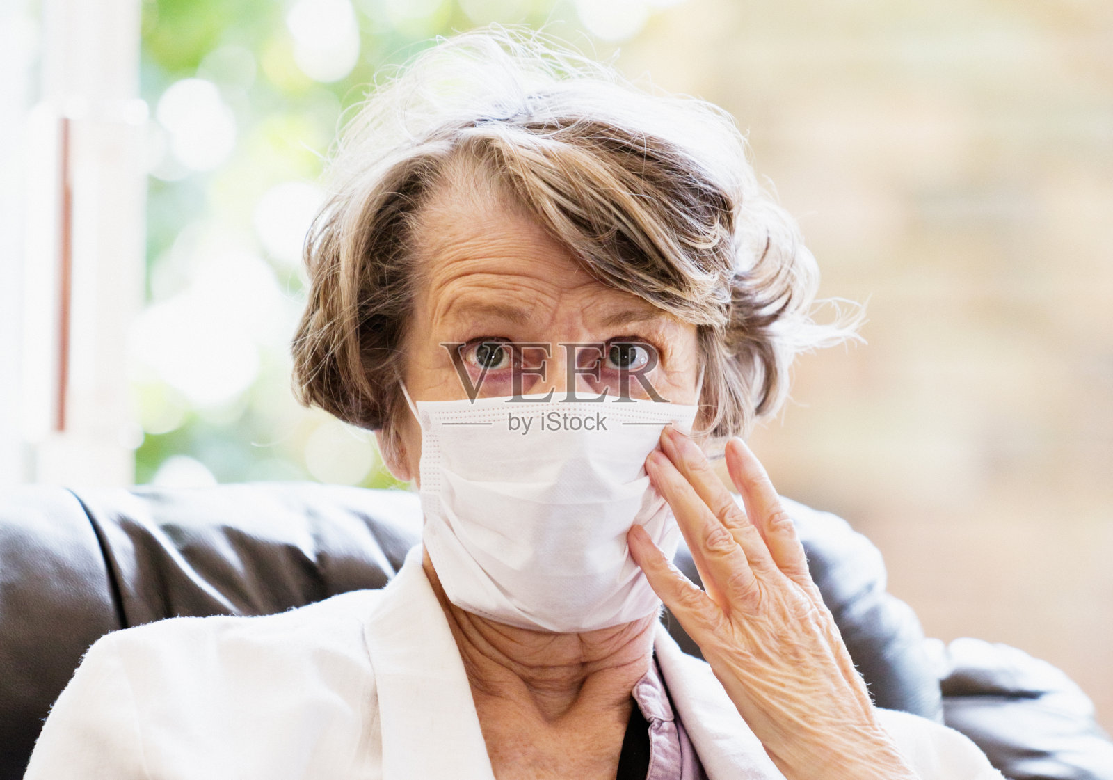 在COVID-19冠状病毒疫情期间，戴口罩避免感染的老年妇女照片摄影图片