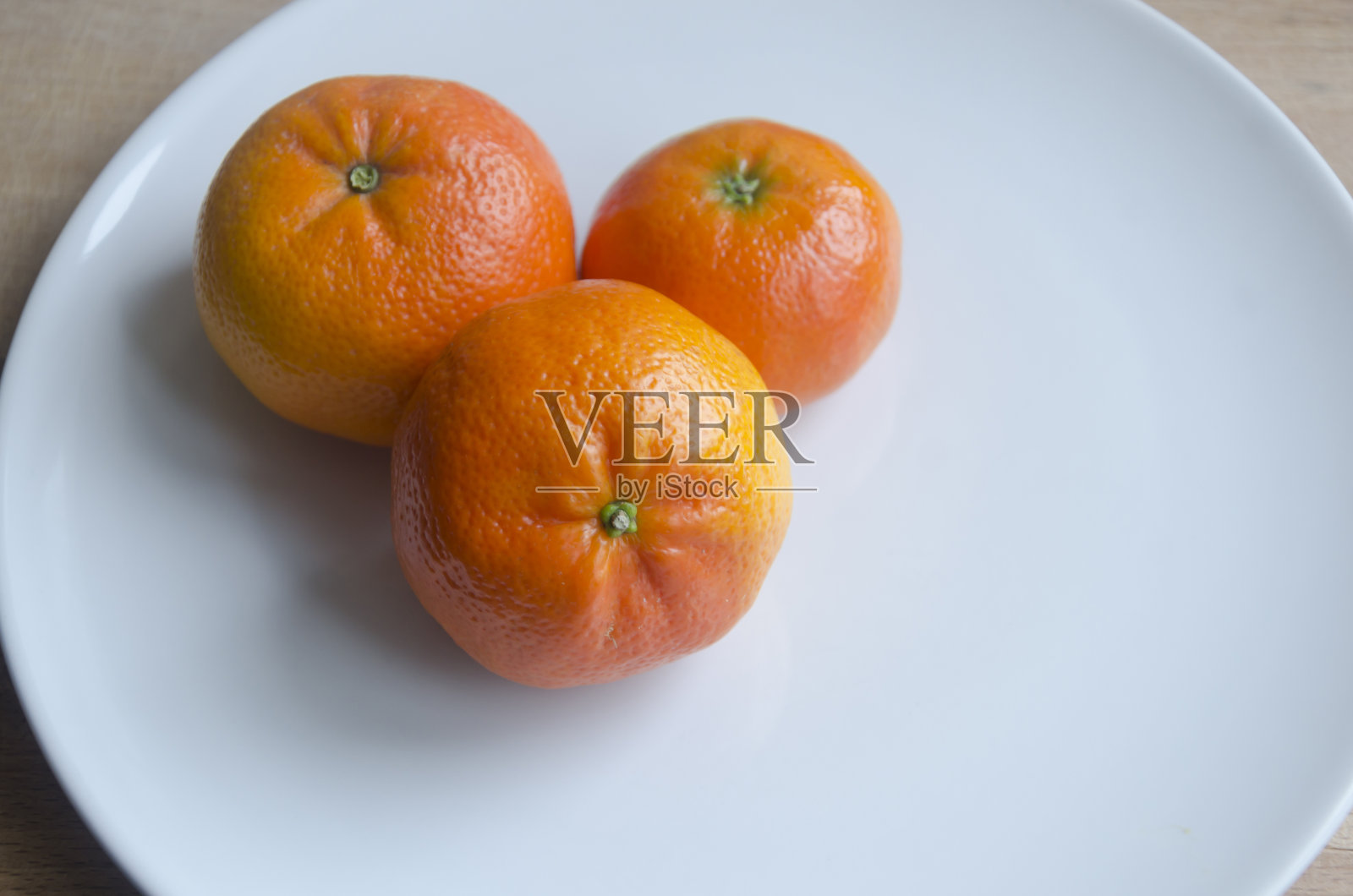白盘子里的橘子照片摄影图片