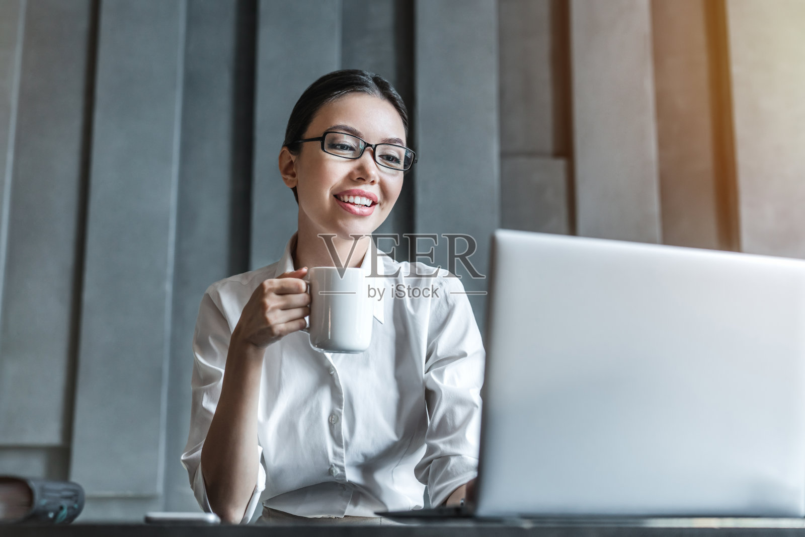 美丽的商务女性用笔记本电脑喝咖啡照片摄影图片
