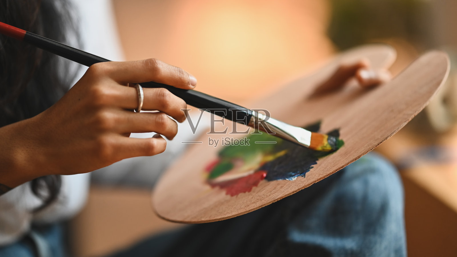 裁剪图像的艺术家女人的手画油画颜色在画布上的画笔在现代艺术工作室。年轻的艺术家/画家的概念。照片摄影图片