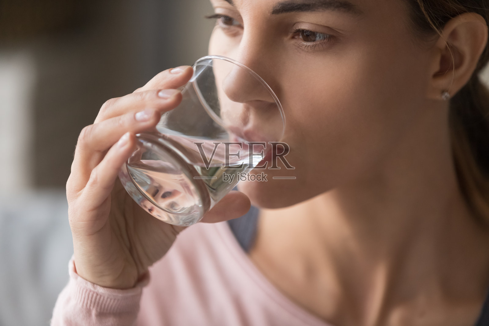 口渴的年轻女子手持酒杯饮用矿泉水的概念照片摄影图片