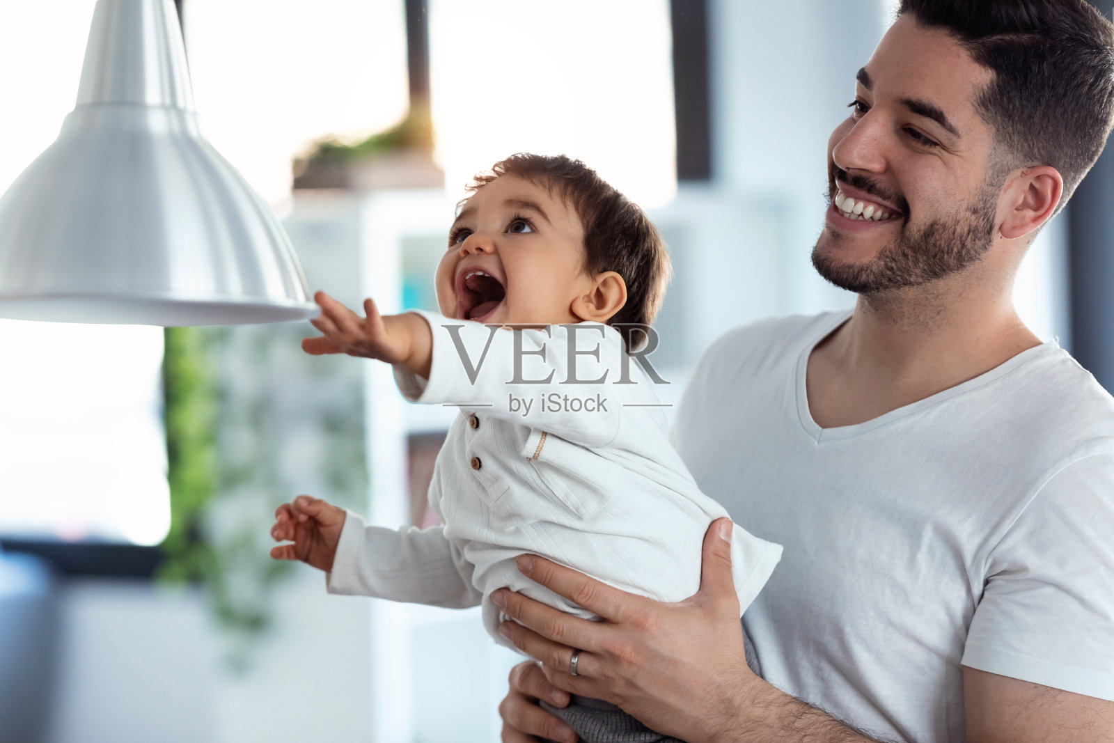 快乐的年轻父亲和他的孩子一起玩，在厨房里玩得开心照片摄影图片