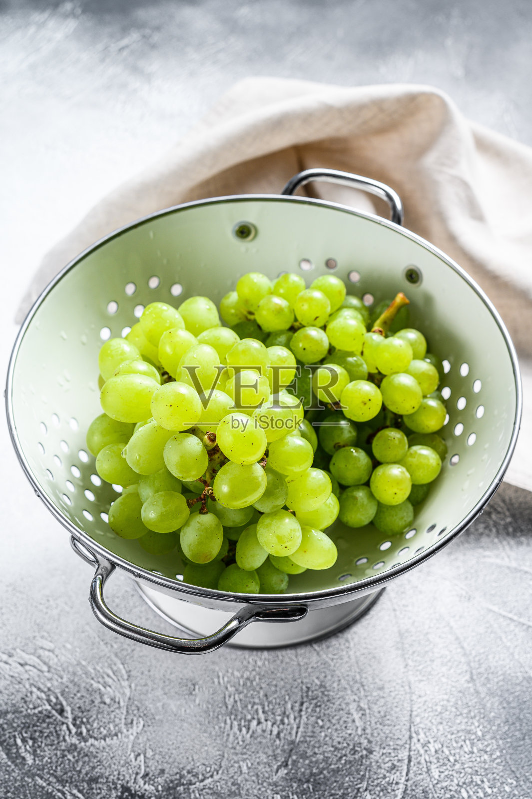 滤锅里的一根成熟的绿葡萄。白色背景。俯视图照片摄影图片
