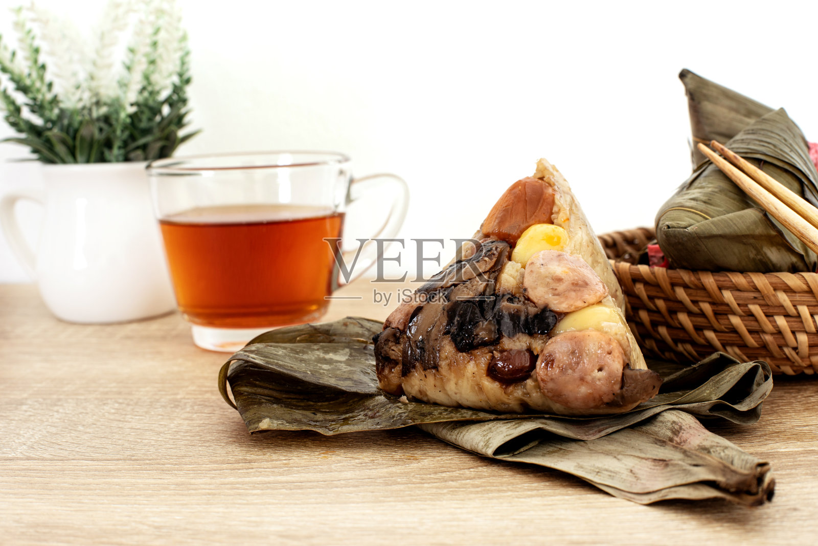 端午时，把粽子或粽子放在木桌上，配上中国茶，这是亚洲的传统食物照片摄影图片