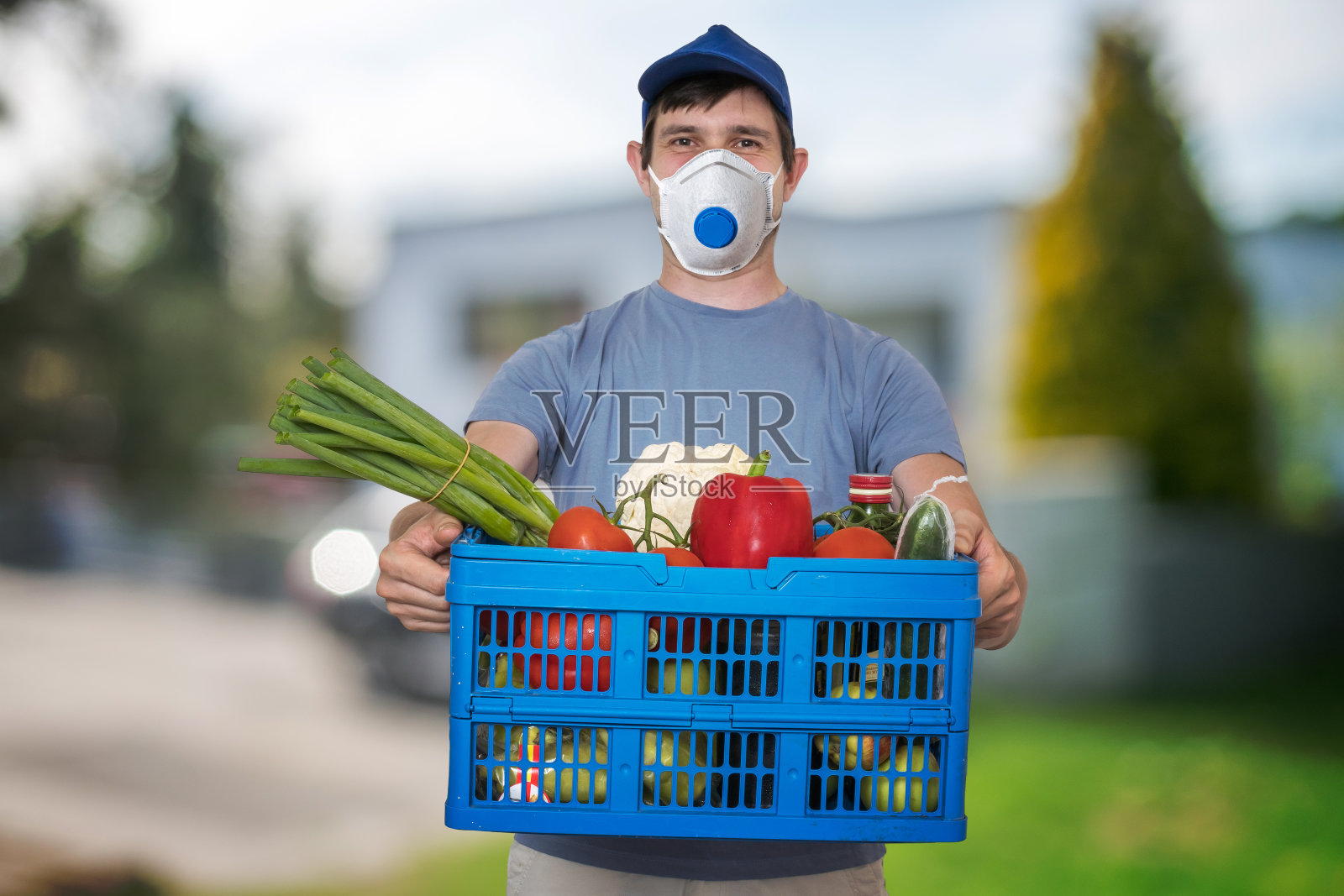 一名戴FFP3口罩的男子在病毒流行期间运送食品和杂货。照片摄影图片