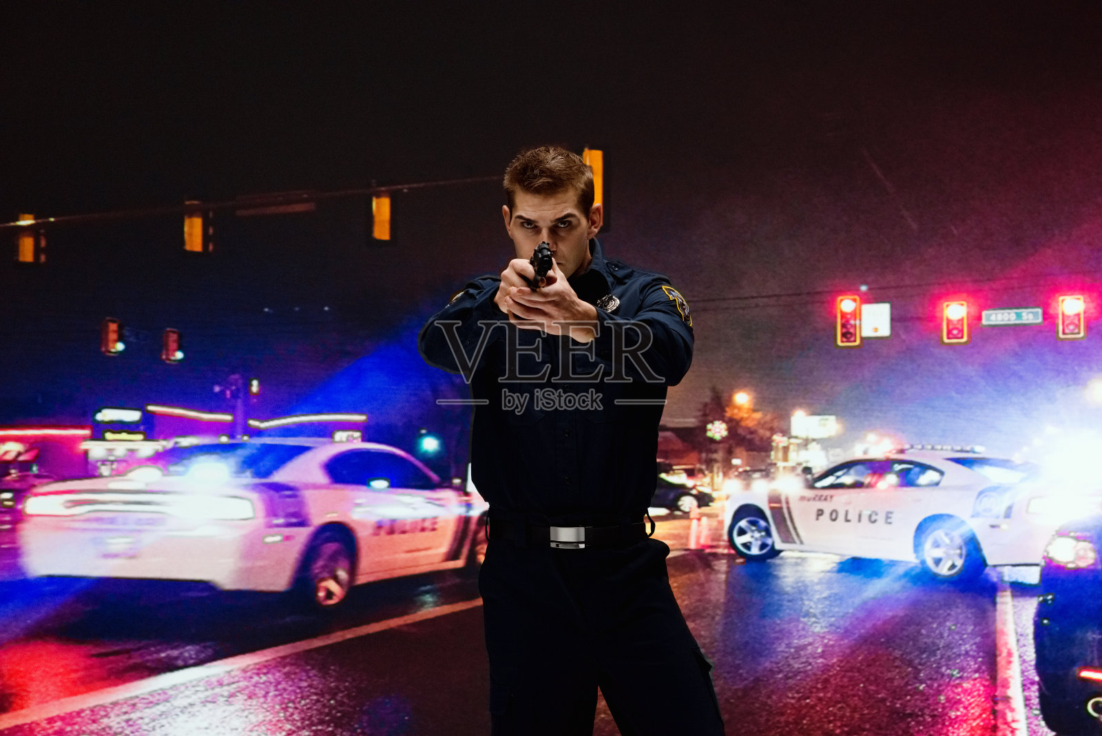 白种年轻男性安全人员戴着警徽和使用枪抢救照片摄影图片