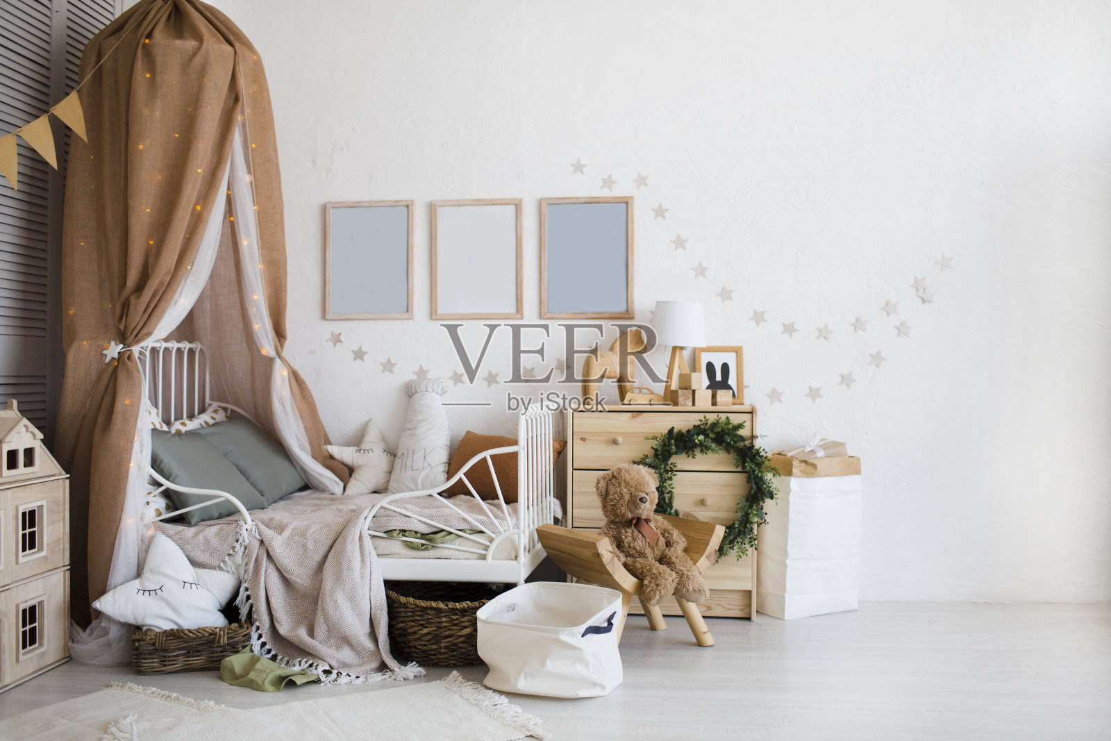 时尚的斯堪的纳维亚婴儿房与婴儿床，梳妆台，木制玩具和灯。“零浪费”。环保的材料照片摄影图片