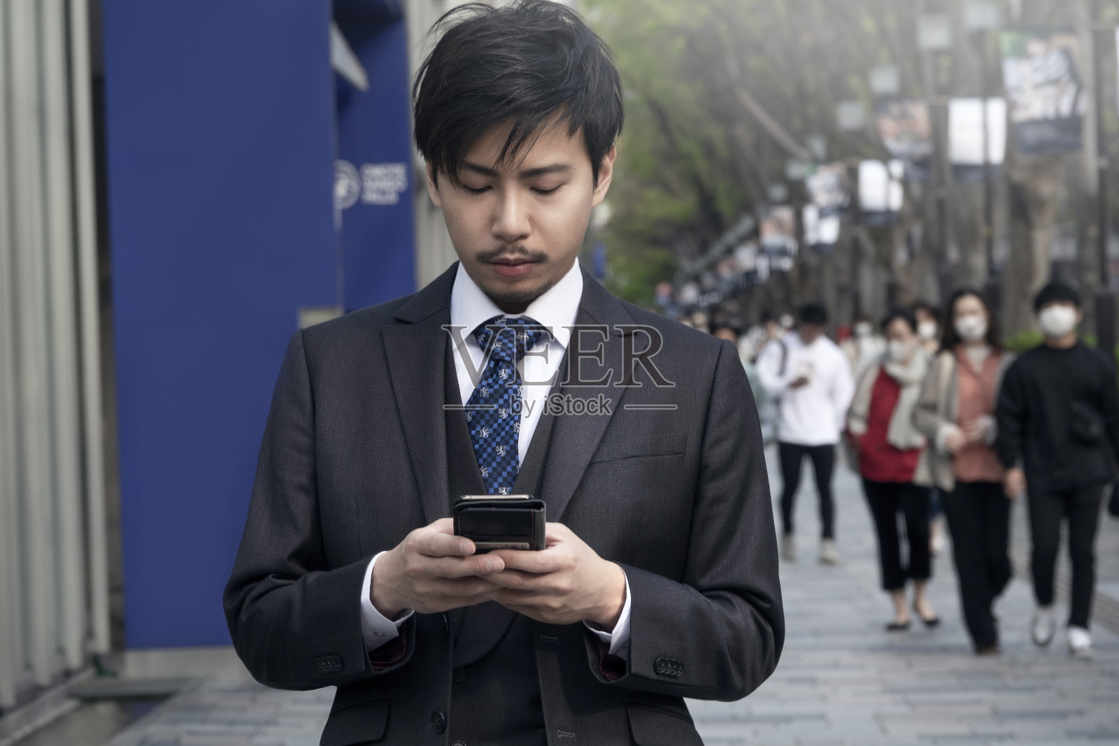 年轻的亚洲商人在街上使用智能手机照片摄影图片