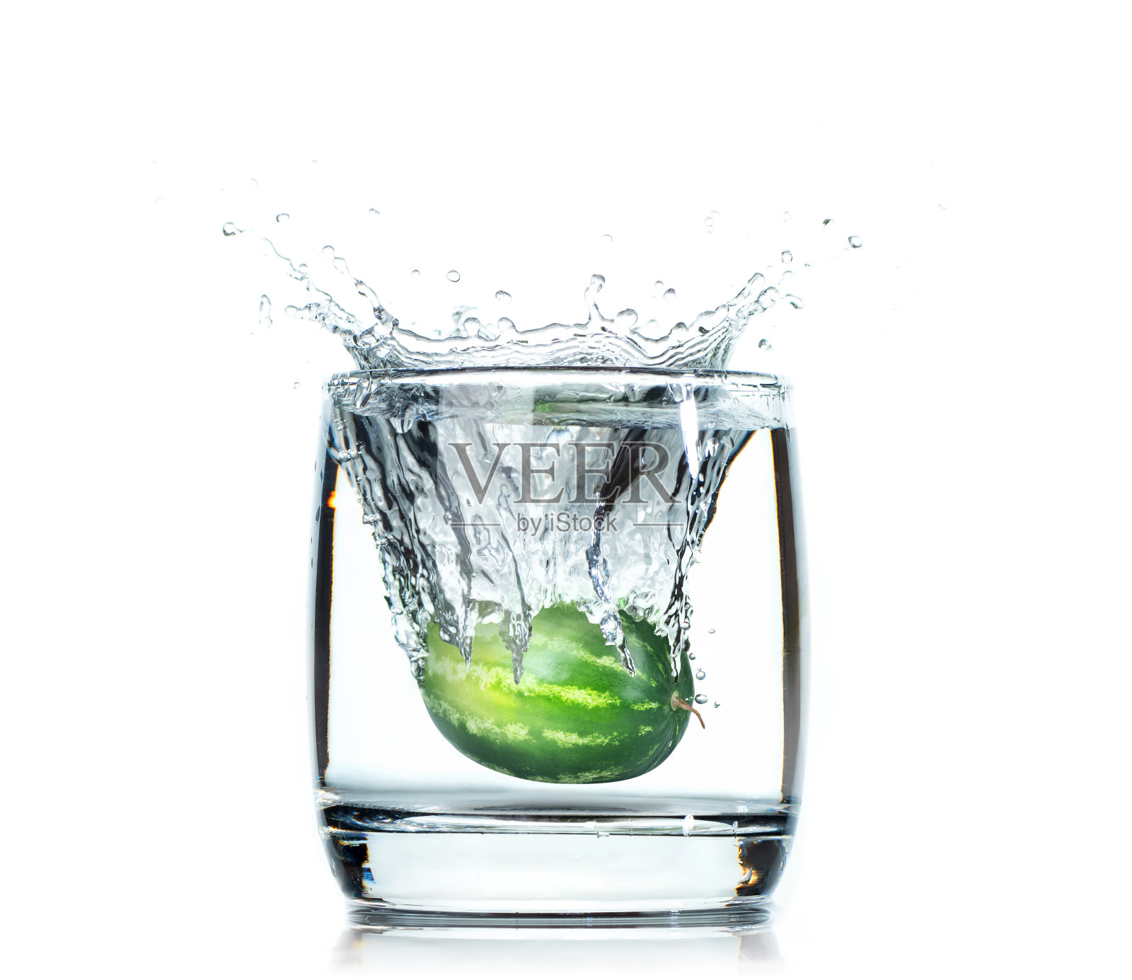 熟透的绿西瓜滴入盛有水的玻璃杯中。在白色背景上隔离照片摄影图片