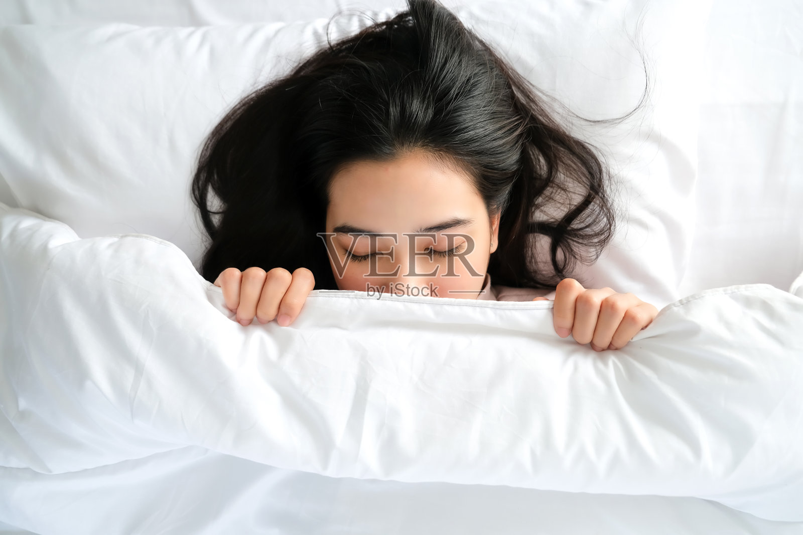 俯视图的肖像年轻美丽的亚洲女人睡在白色的床下毯子在现代卧室照片摄影图片