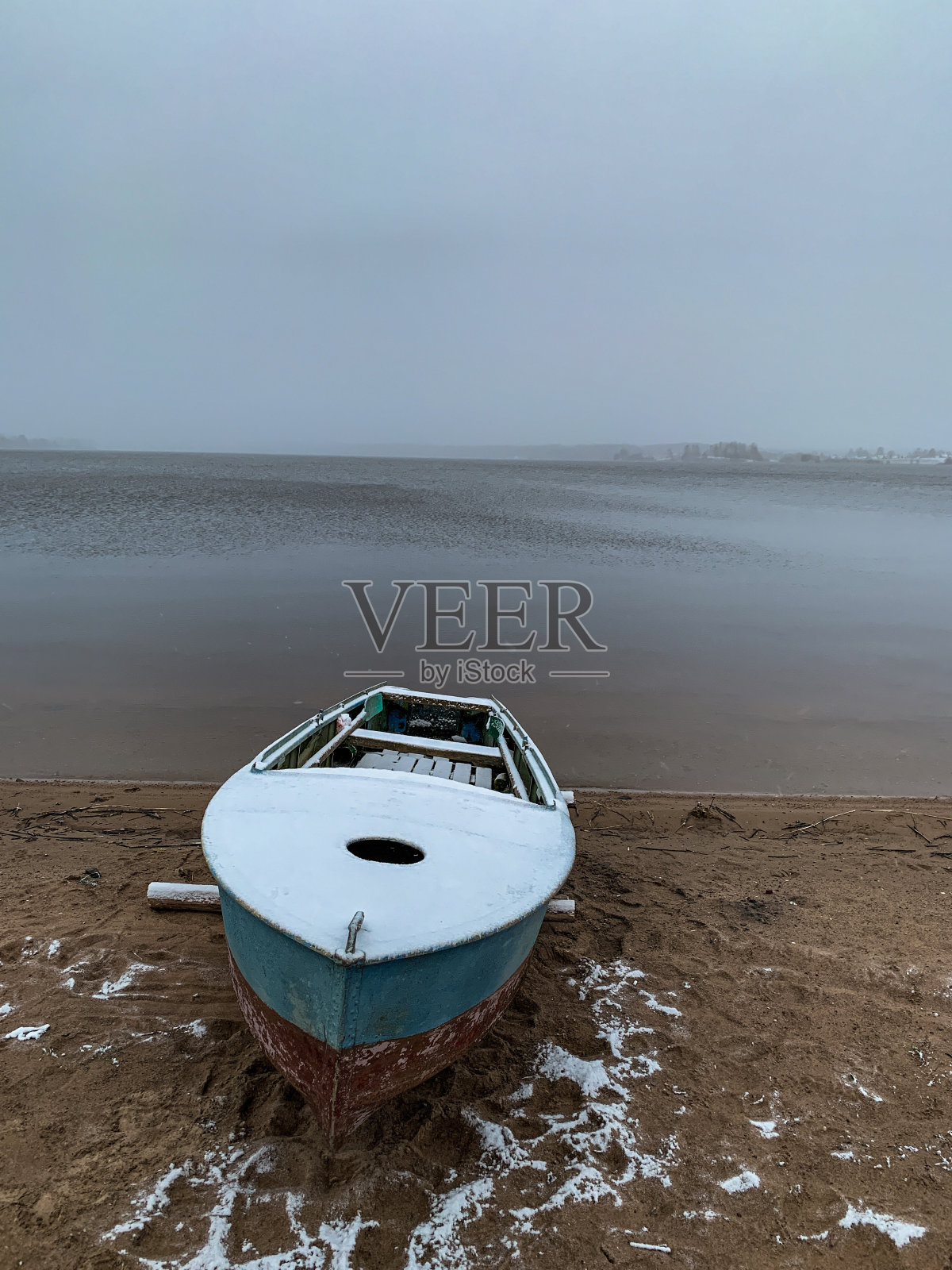 白雪覆盖的小船。湖的景色。照片摄影图片