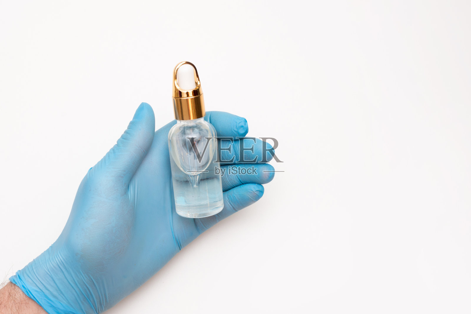 一名男子(护士、科学家)手持一个装有液体(液体)的玻璃瓶在实验室里进行化学隔离。照片摄影图片