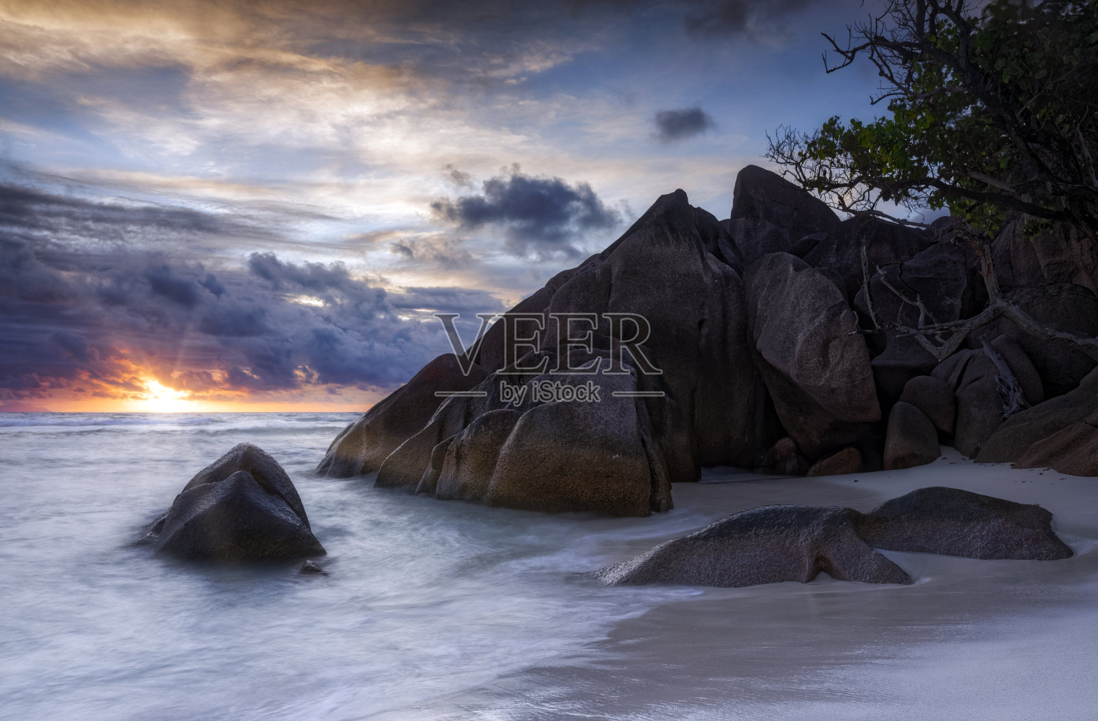 海滩上美丽的日落，典型的花岗岩岩层在Praslin岛，花岗岩塞舌尔，印度洋群岛国家照片摄影图片