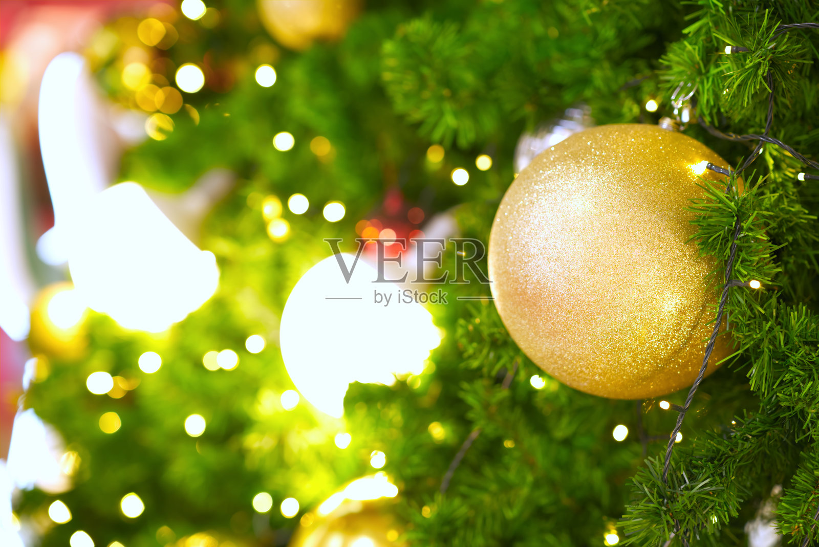 玩具球金色塑料棒用来装饰圣诞树和美丽的黄色散焦灯照片摄影图片