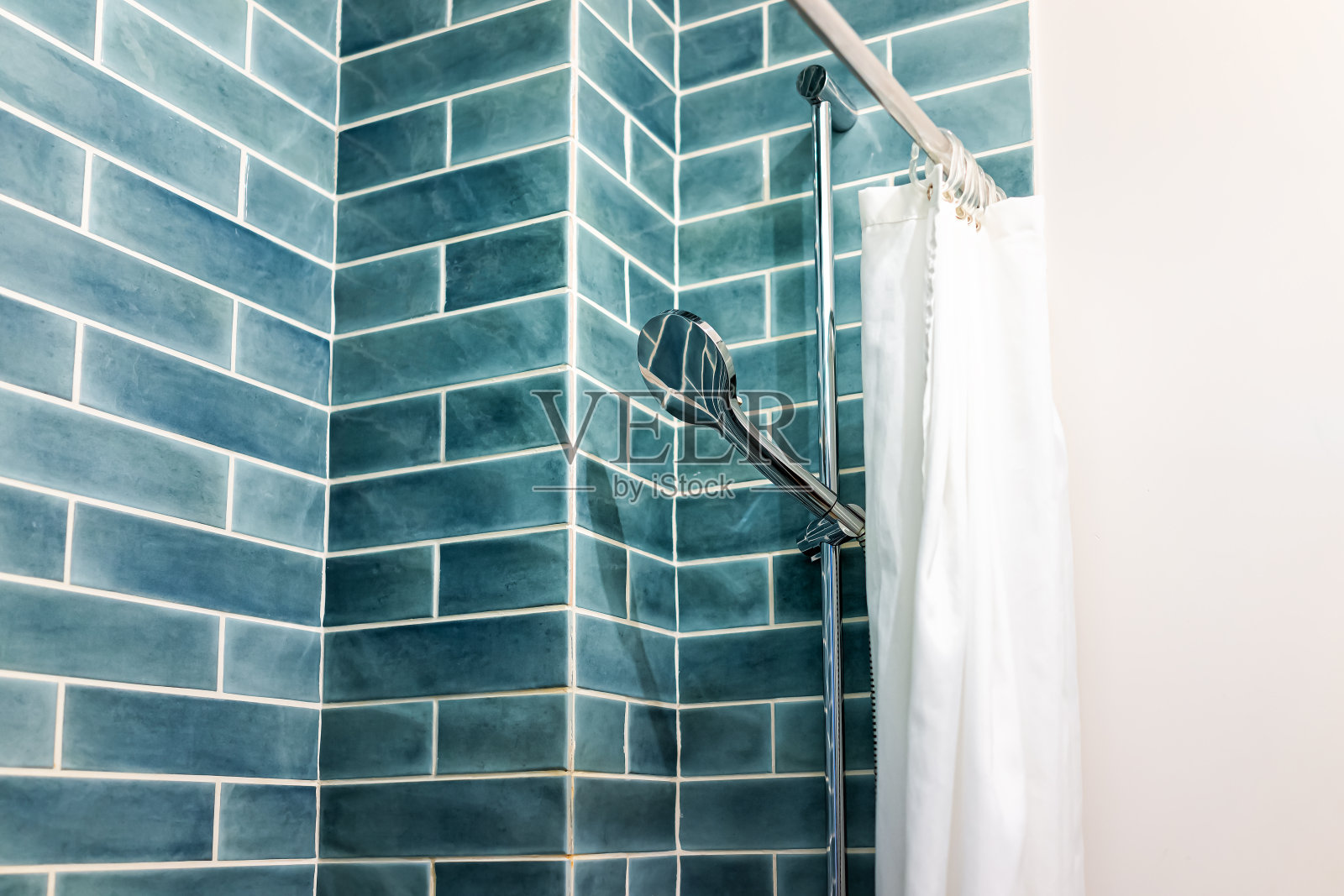 现代极简主义浴室与蓝色绿色瓷砖瓷砖淋浴和头在明亮的房间与窗帘照片摄影图片