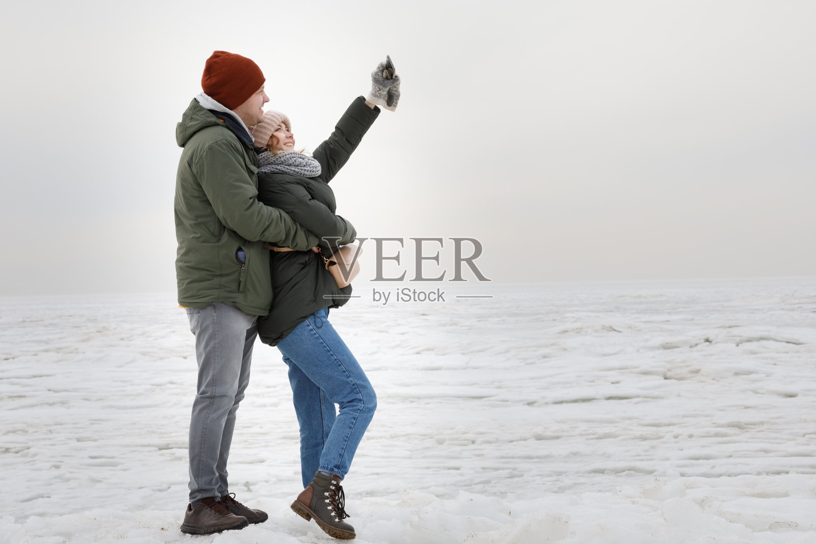 selfies在冬天。在结冰的湖面上拍摄的一对夫妇。照片摄影图片