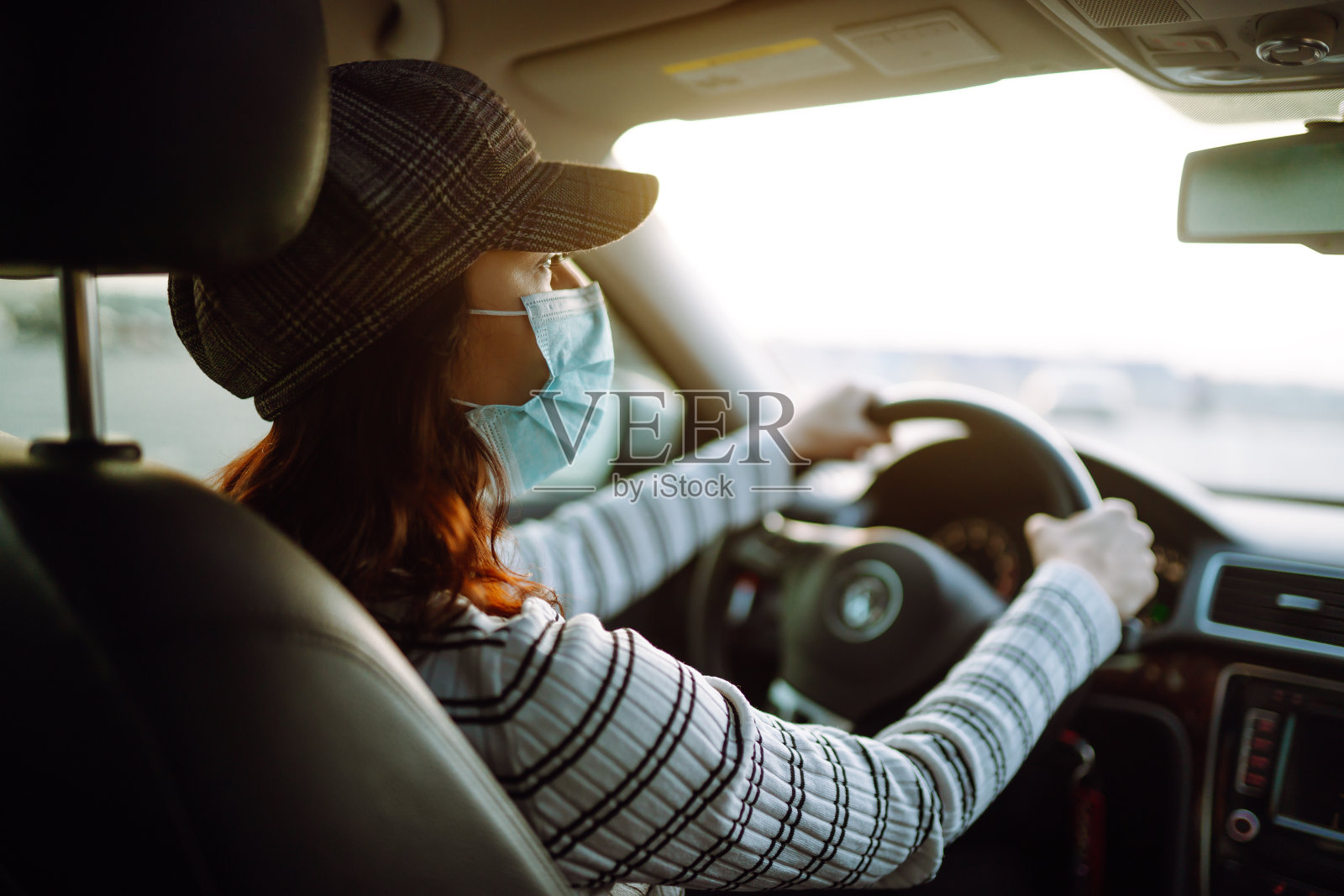年轻女子开车时脸上戴着防护面具照片摄影图片