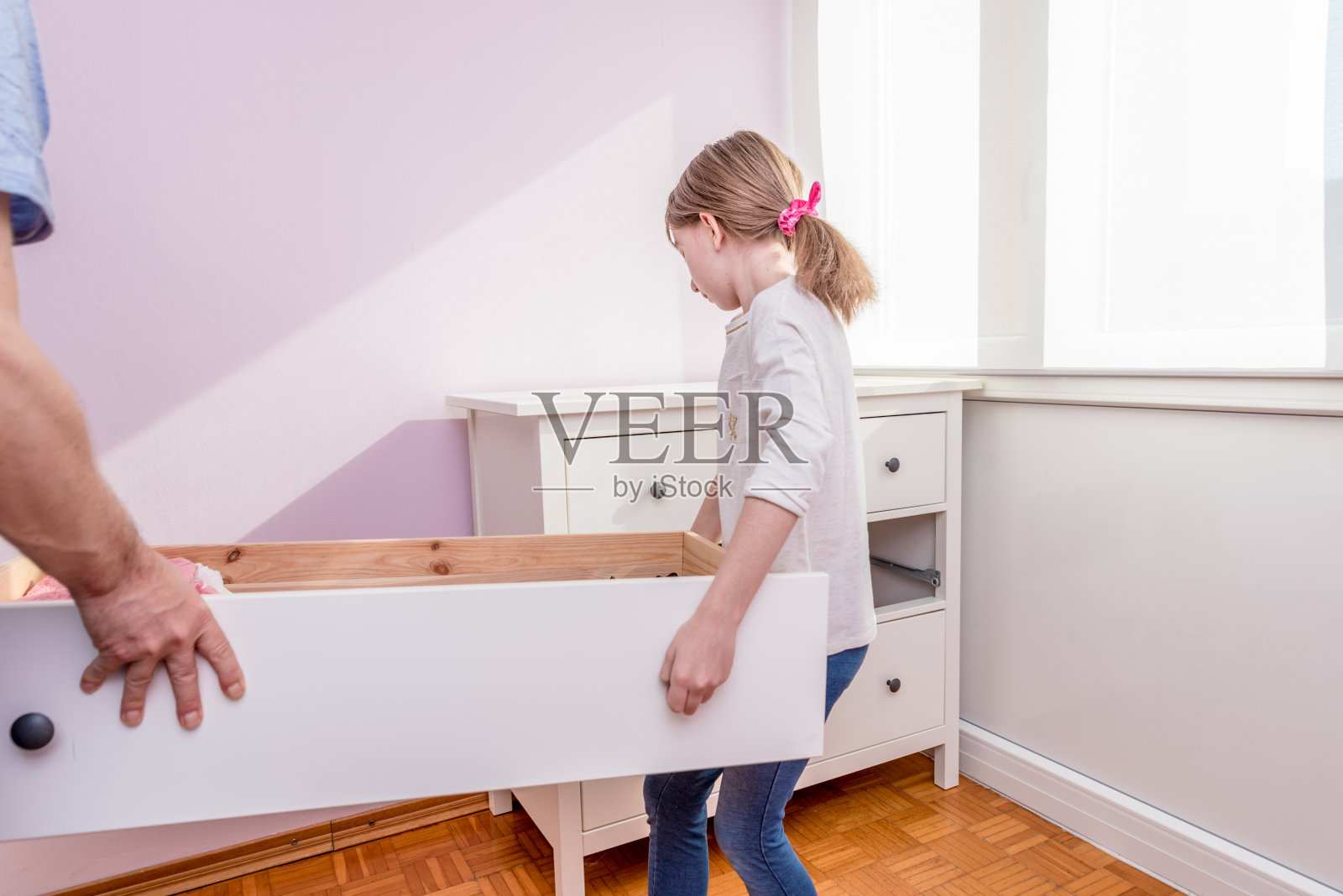 新冠肺炎封锁期间，父亲帮助女儿重新组装卧室里的家具照片摄影图片