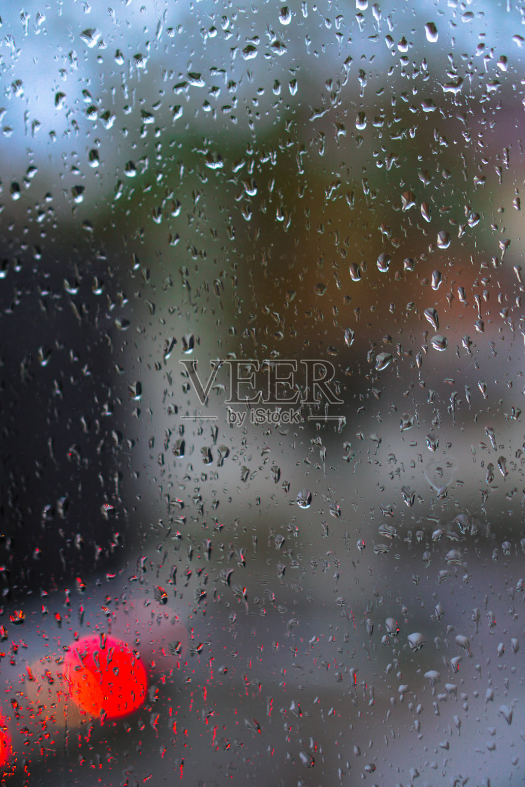窗户俯瞰着下雨的街道。阴沉的傍晚，从街道看出去。落在玻璃上和车里的散焦。设计库存背景照片摄影图片