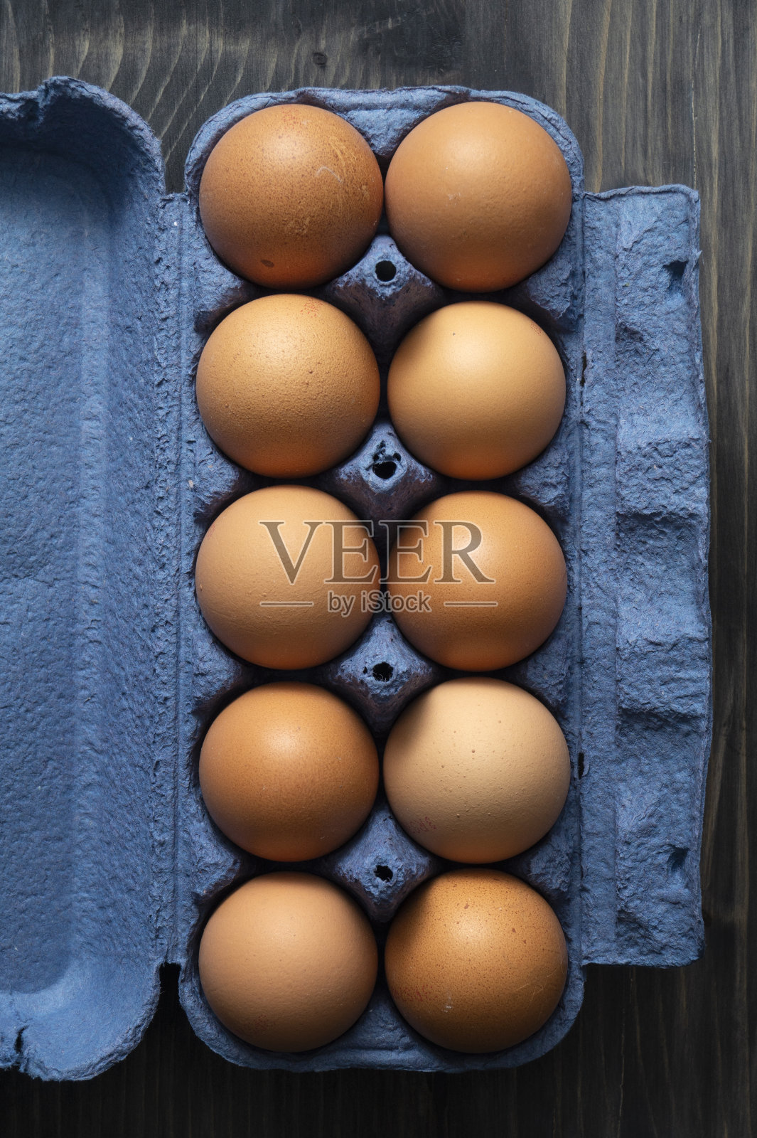 有机棕色鸡蛋装在纸盒里，放在质朴的木桌背景上照片摄影图片