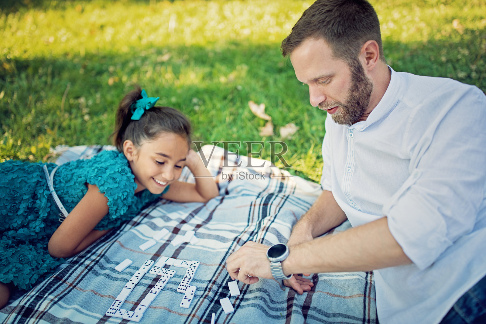 女儿和父亲在公园玩多米诺骨牌照片摄影图片