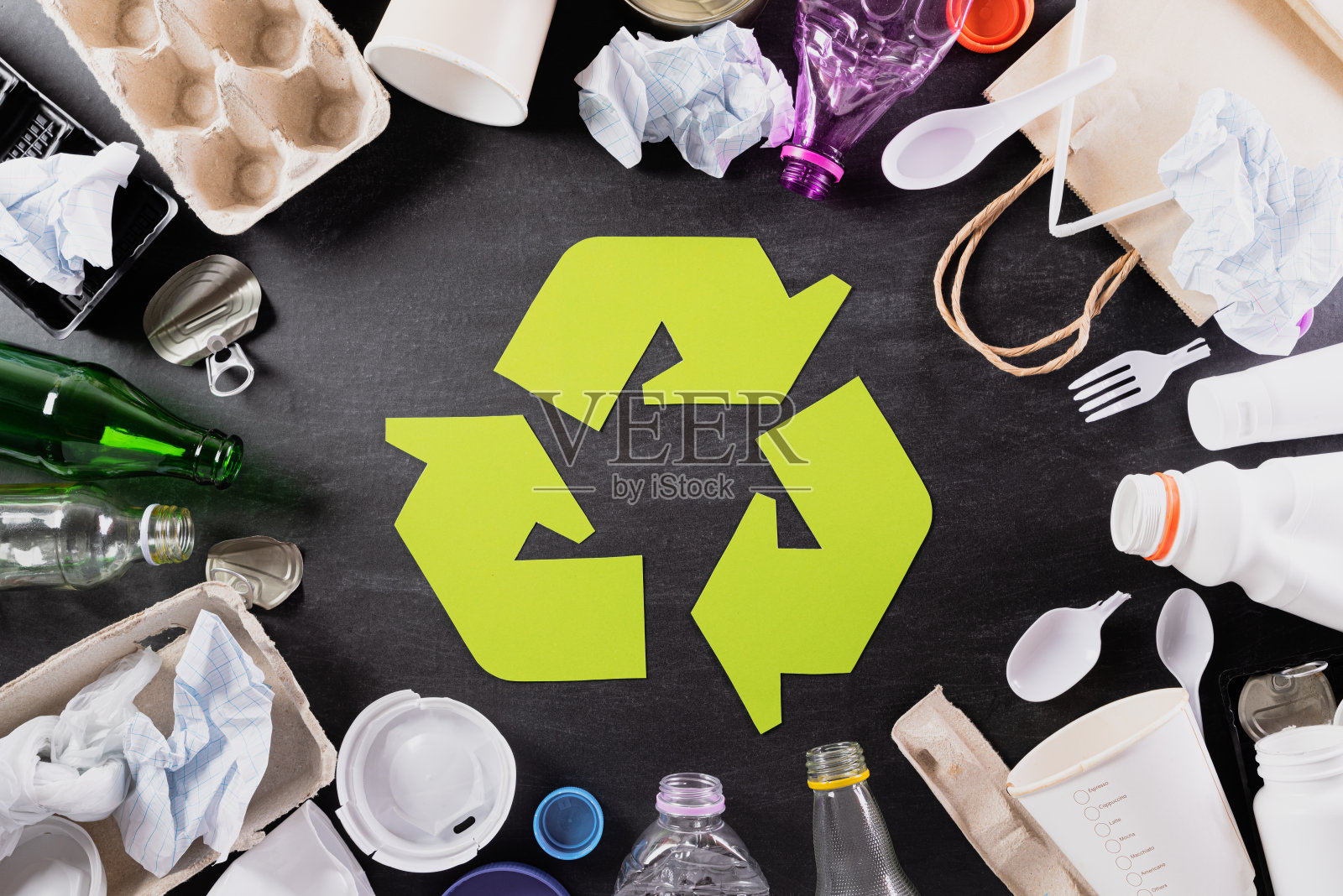 俯视图不同的垃圾材料与回收符号在黑色背景。回收，世界环境日，绿色和生态概念照片摄影图片