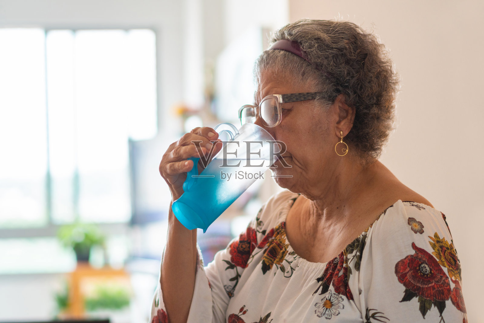 在家里喝水的女人照片摄影图片