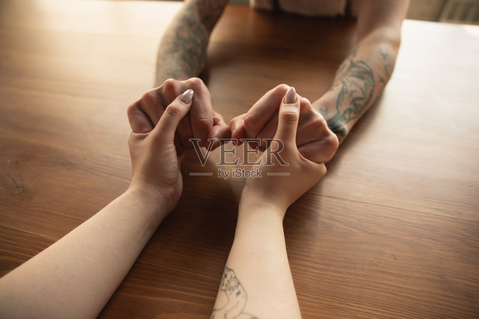 相爱的夫妇牵着手在木制背景的特写，浪漫照片摄影图片