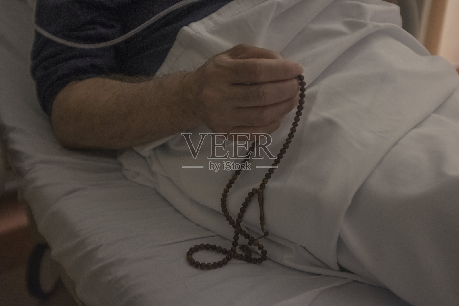 在病床上祈祷的男人照片摄影图片