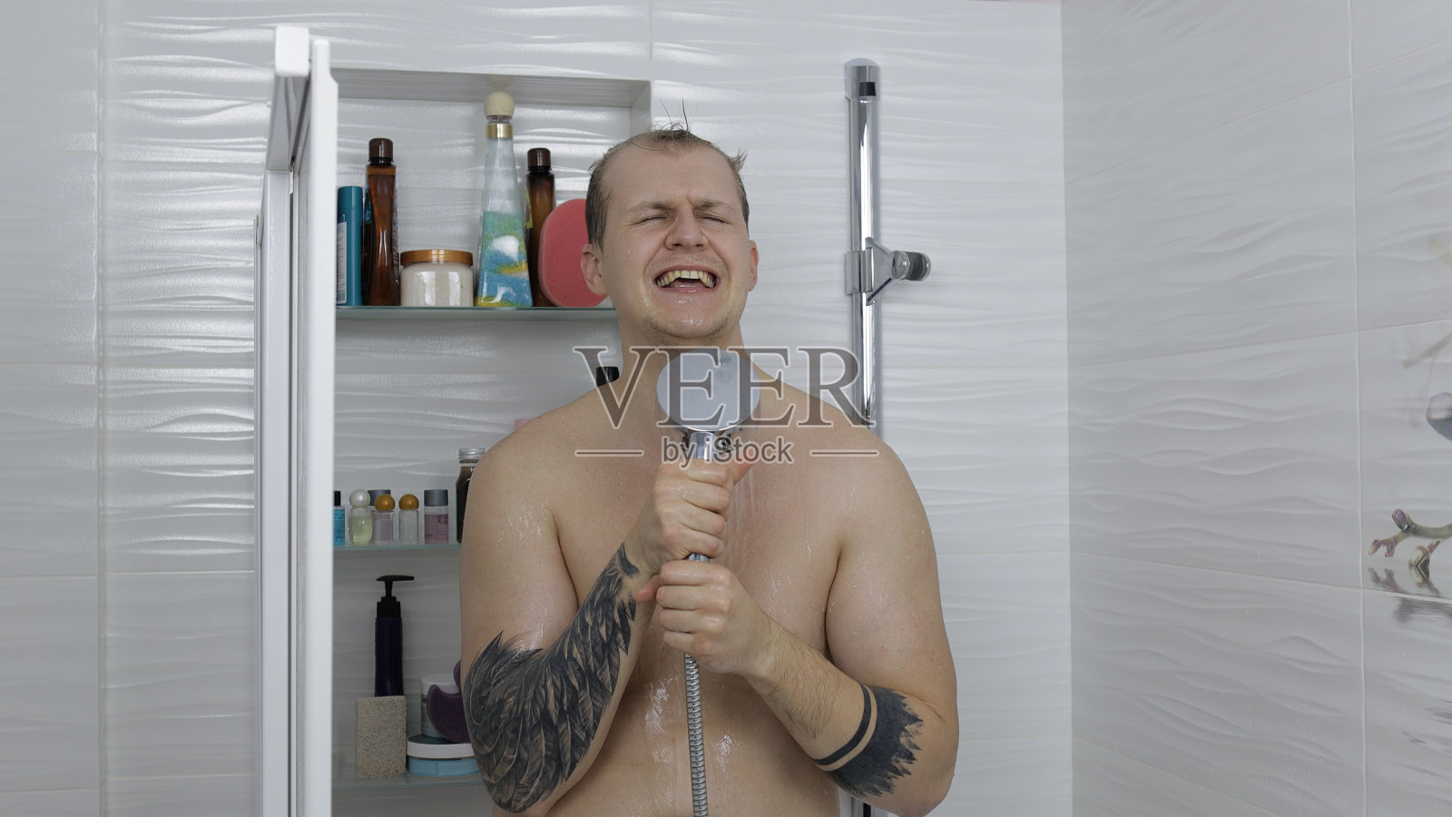 年轻英俊的胖男人在浴室洗澡。情感上的歌舞照片摄影图片