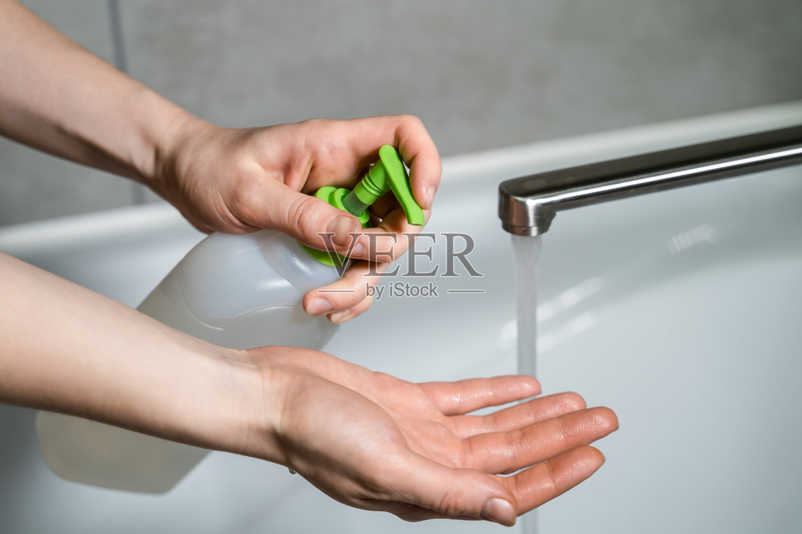女人推着皂液机，把皂液挤到手上。女人的手从皂液盒里挤出肥皂液。洗你的手。冠状病毒或新冠肺炎预防。照片摄影图片