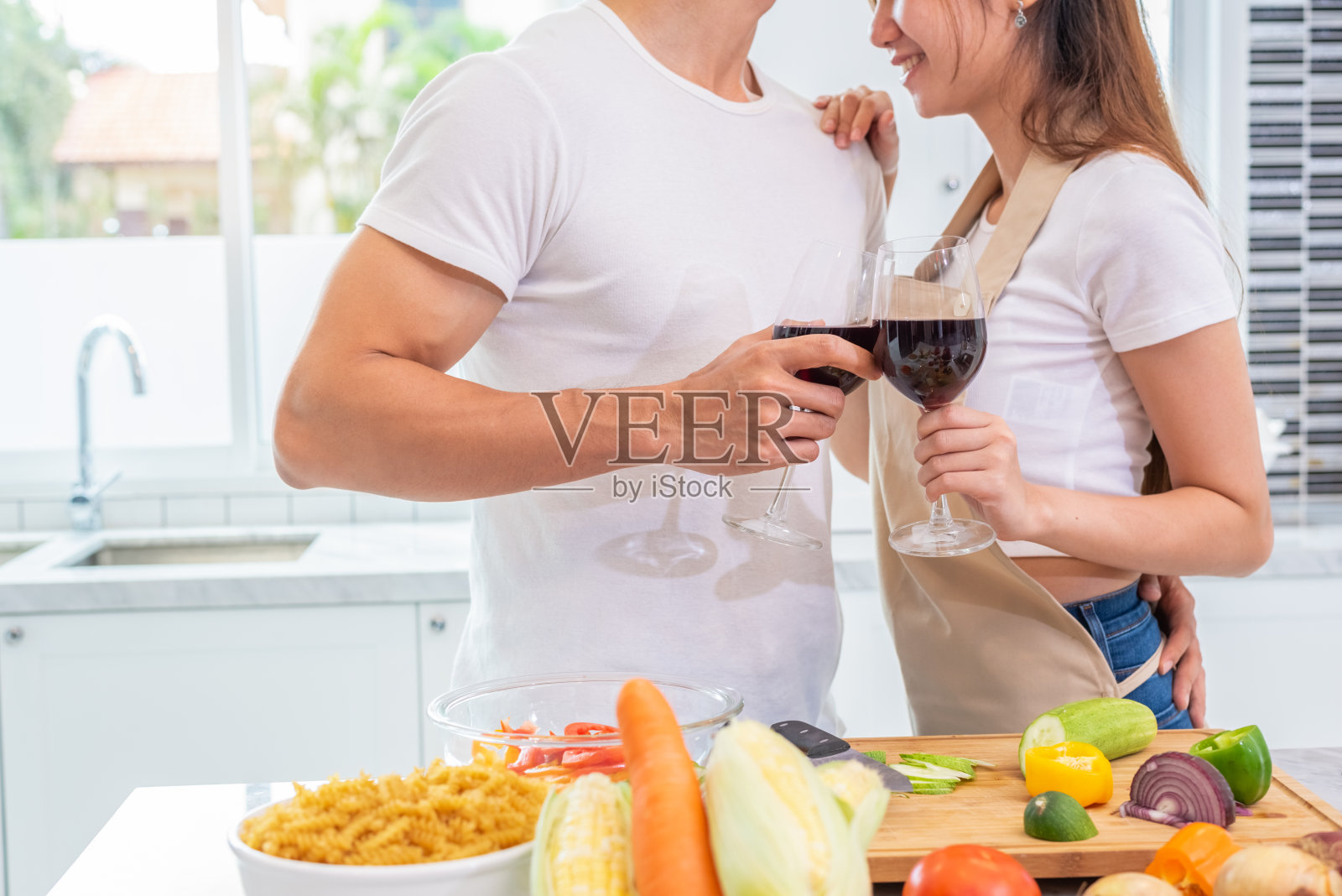 特写喝酒上幸福的亚洲年轻夫妇手在家庭厨房。男朋友和女朋友一起做饭。人们的生活方式和浪漫的关系概念。情人节照片摄影图片