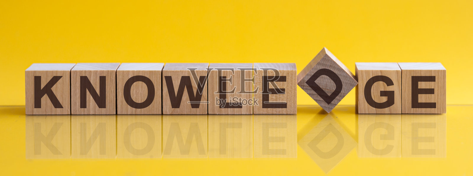 单词知识是由放在桌子上的木质积木和浅黄色的背景构成的。概念照片摄影图片