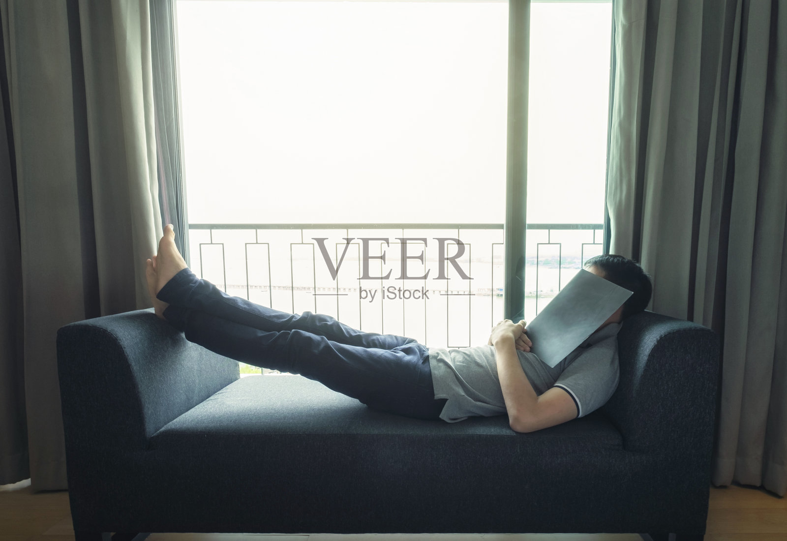 一个男人在窗边的现代沙发上休息照片摄影图片