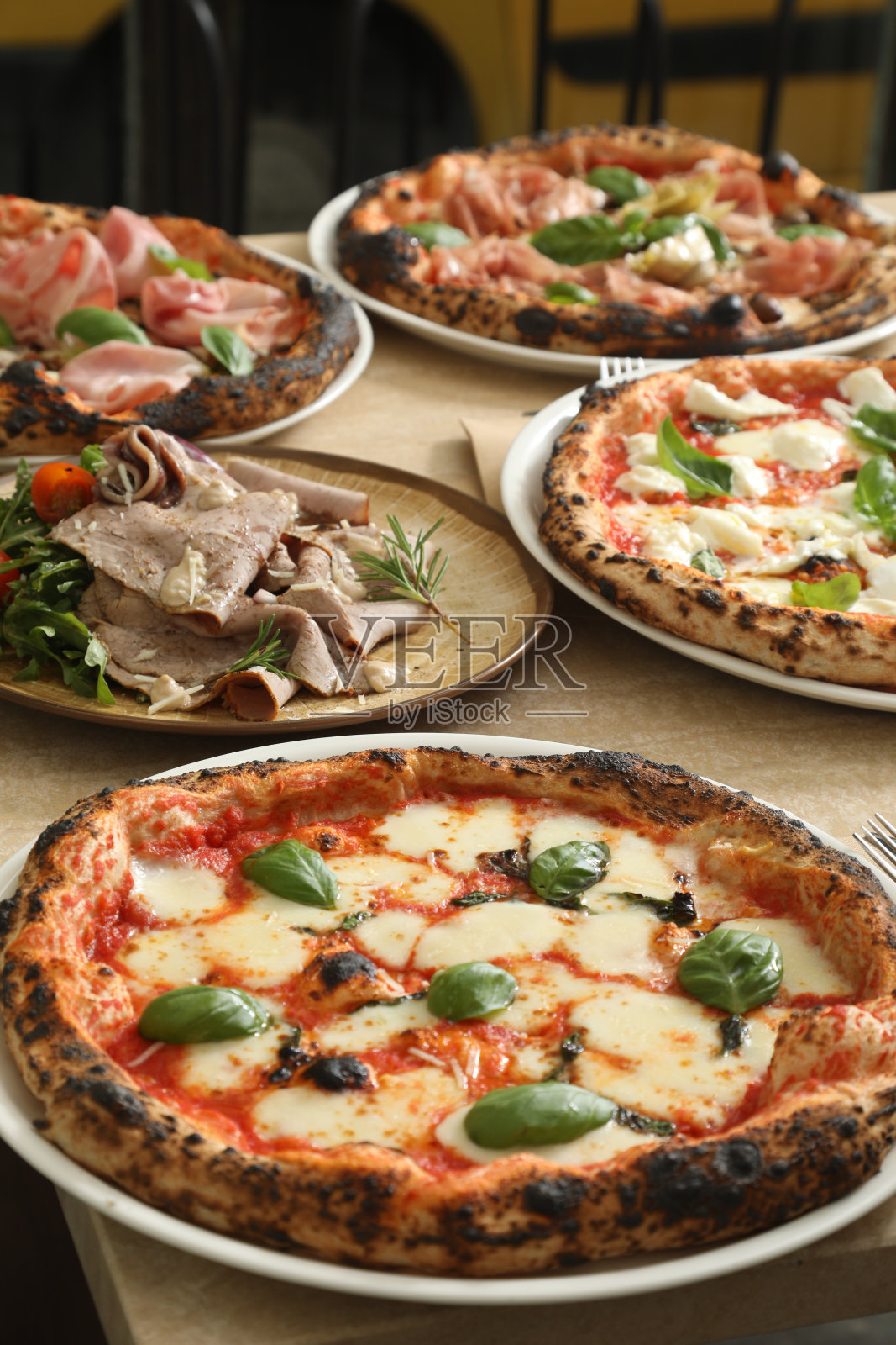 五个热腾腾的意大利披萨摆在桌上照片摄影图片
