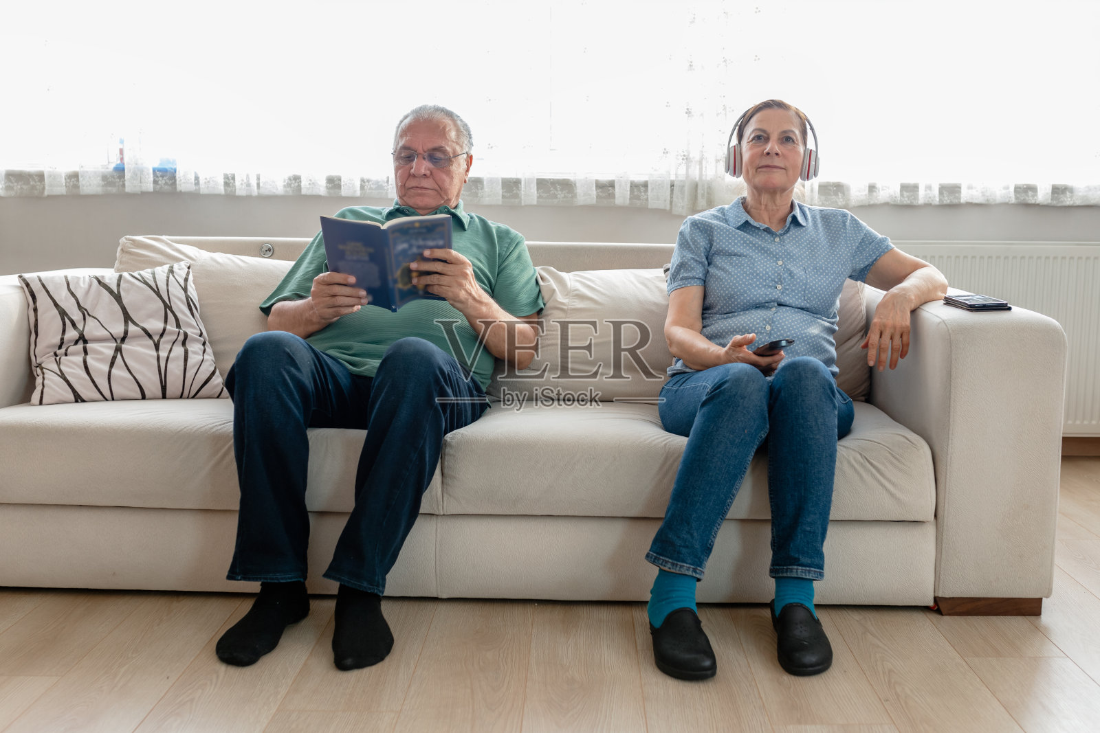 老妇人在看电视，而她的丈夫在看书照片摄影图片