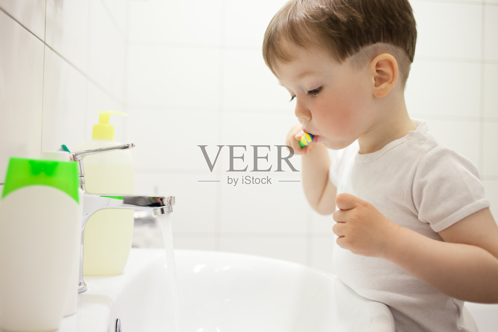 2岁的小男孩在浴室里用牙刷刷牙照片摄影图片